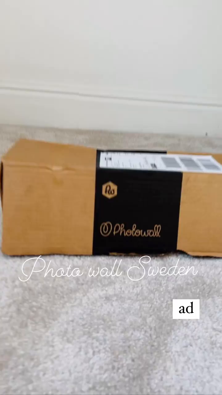 Photowall Sweden package on carpet. Brown cardboard box with black logo band.
