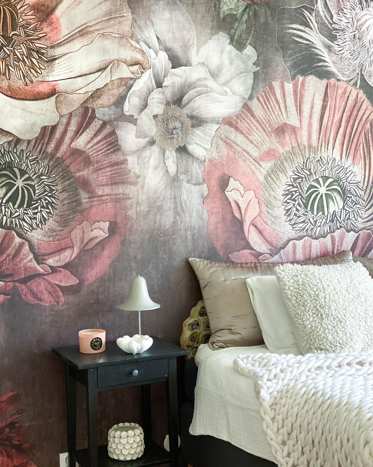 Bedroom with floral wallpaper, black nightstand, and white bedding.