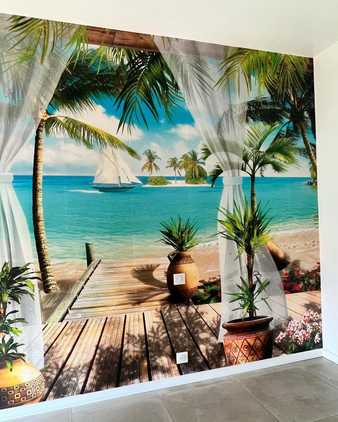Wall mural of tropical beach scene with palm trees, sailboat, and wooden deck.
