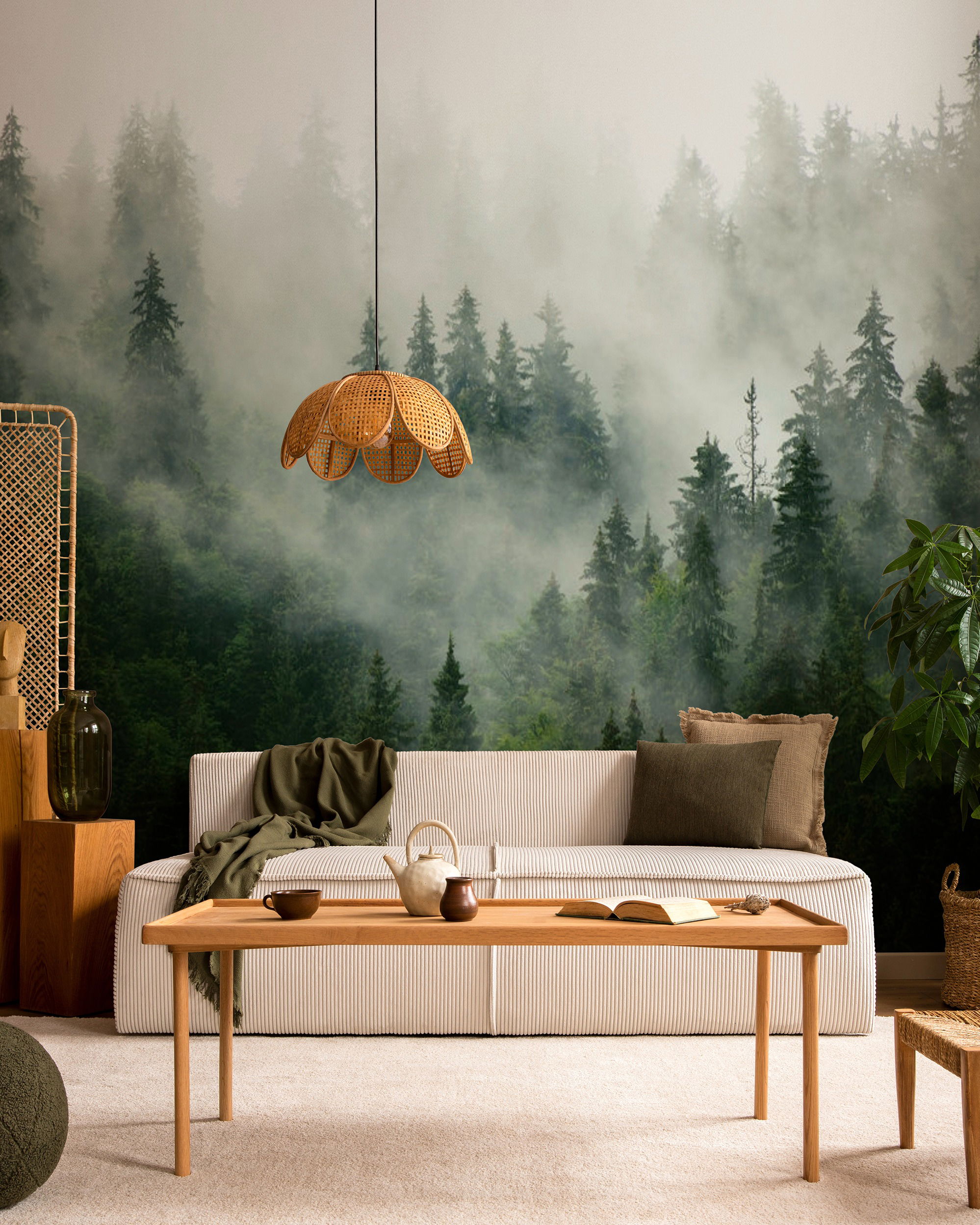 Wohnzimmer mit Waldtapete, weißem Sofa und Couchtisch aus Holz.