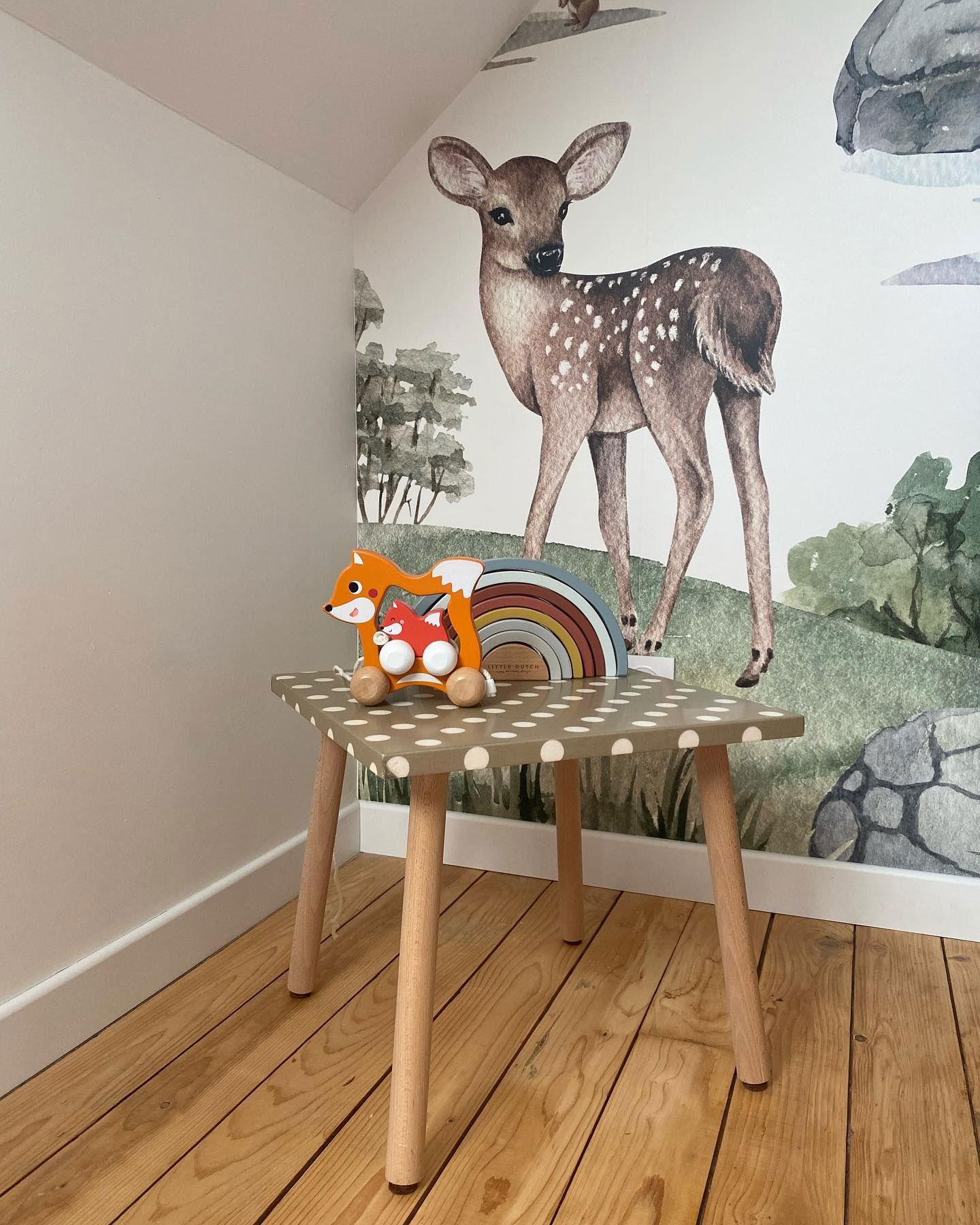 Chambre d'enfant avec papier peint de cerfs, table à pois et jouet à tirer renard Little Dutch.