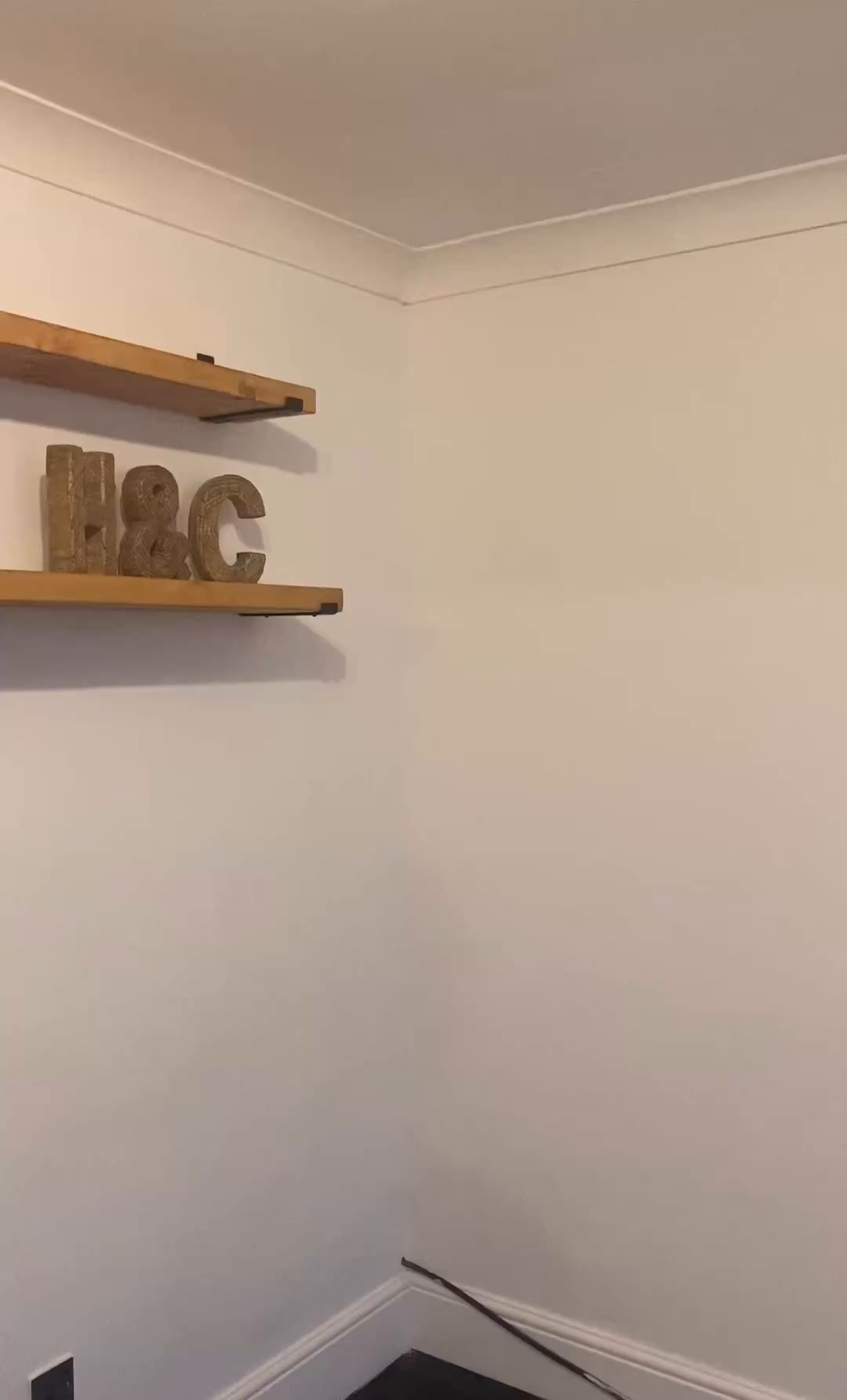Wooden shelves with "H&C" decor on a white wall.