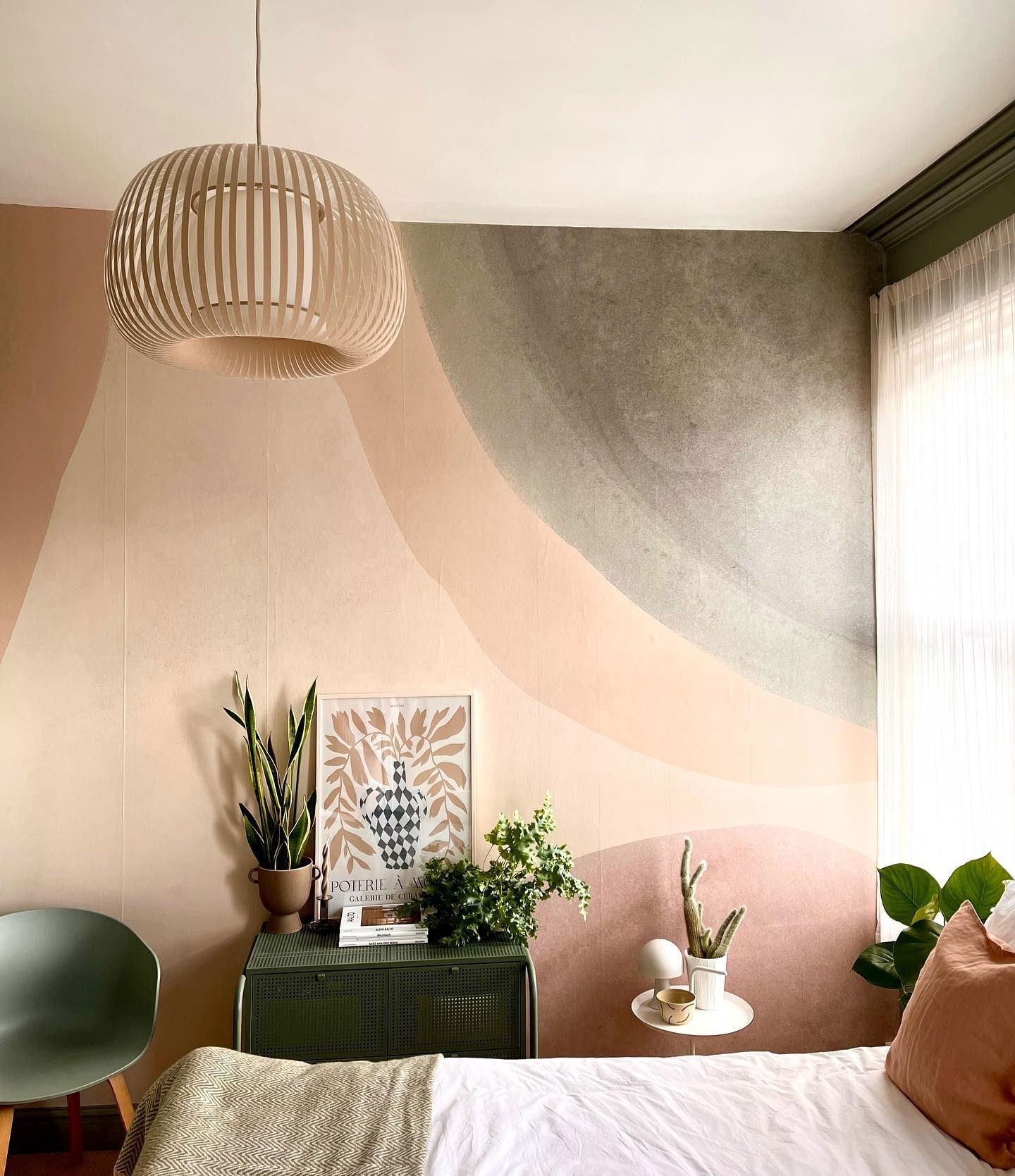 Bedroom with painted wall mural, wood pendant light, and green accents.