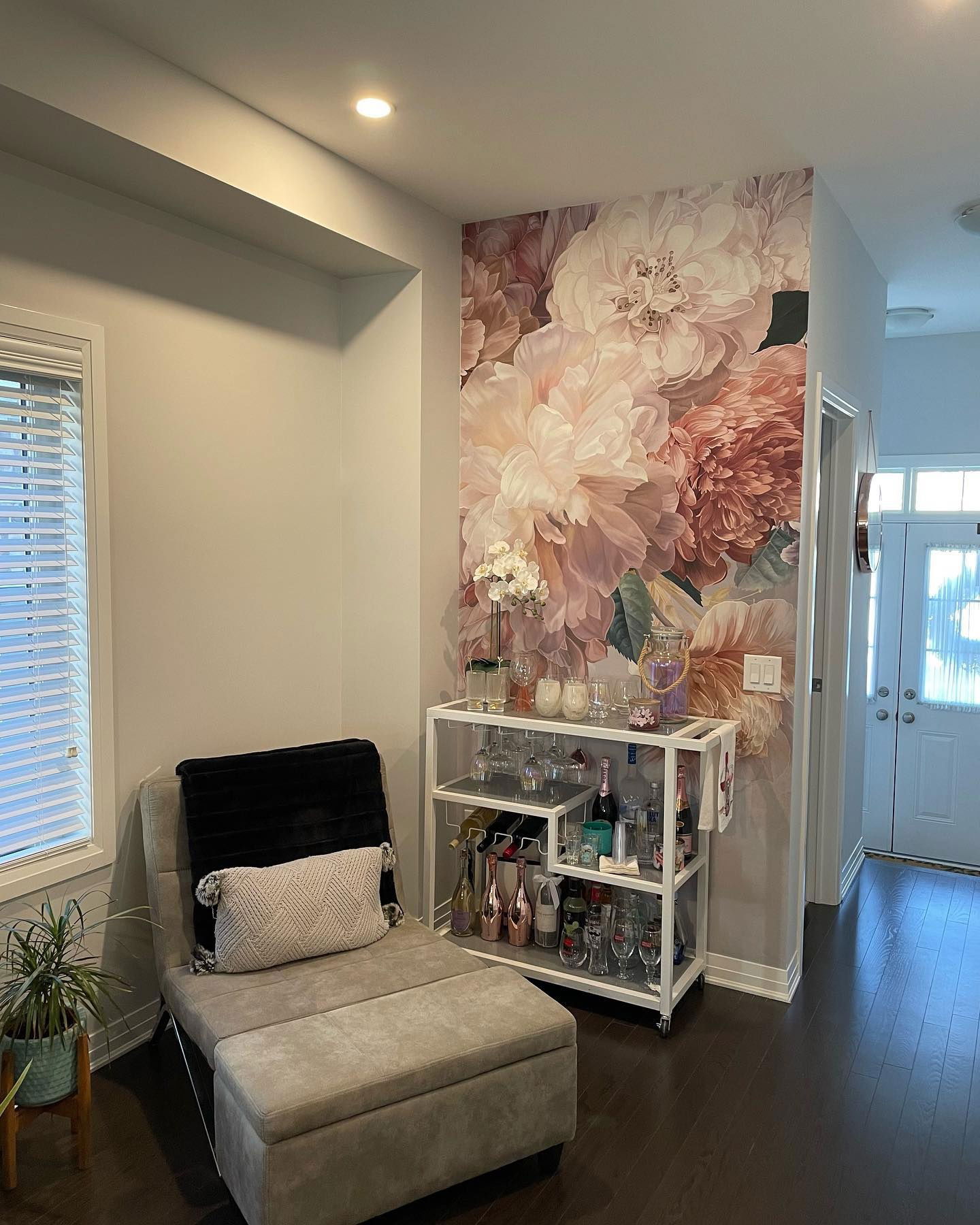 Living room with floral wallpaper, chaise lounge, and white bar cart.