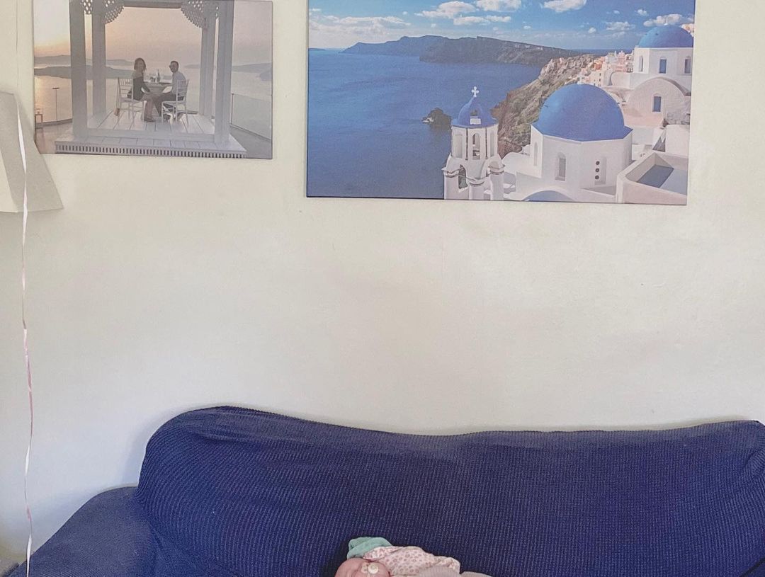 Interiør med Santorini kunsttryk, par spise tryk og blå sofa.