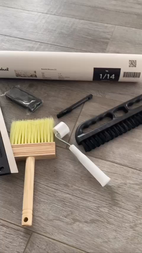 Photowall wallpaper kit with brushes, roller, smoothing tool, and blade.