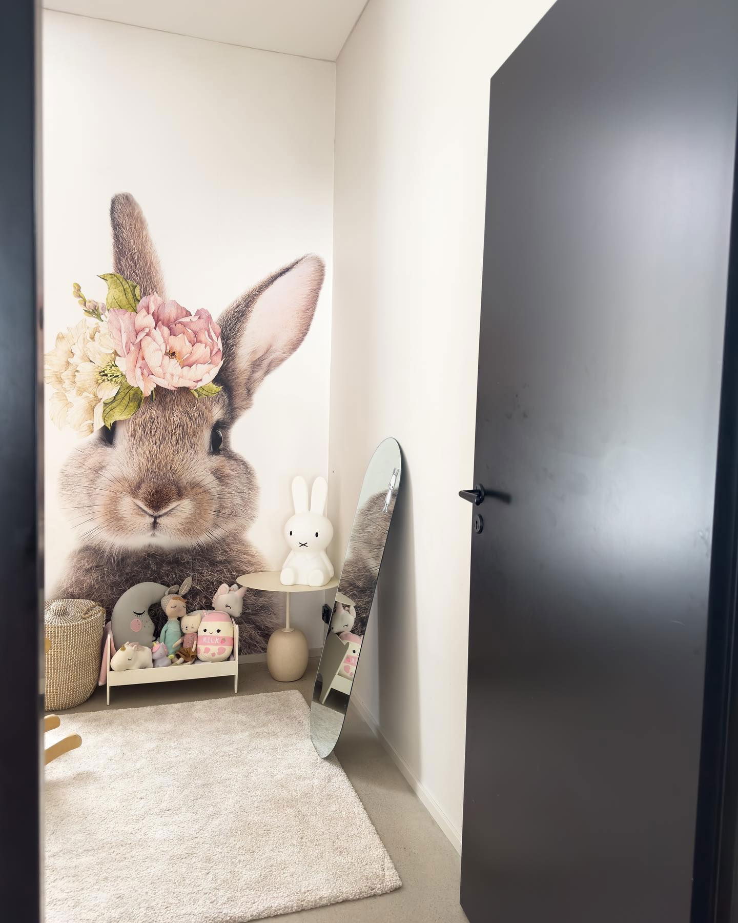 Barneromskrok med kaninveggkunst, plysjleker og Miffy-lampe.