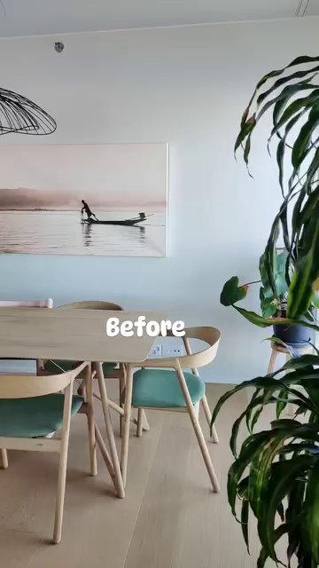 Dining area with light wood table and chairs, green cushions, and a framed boat print.