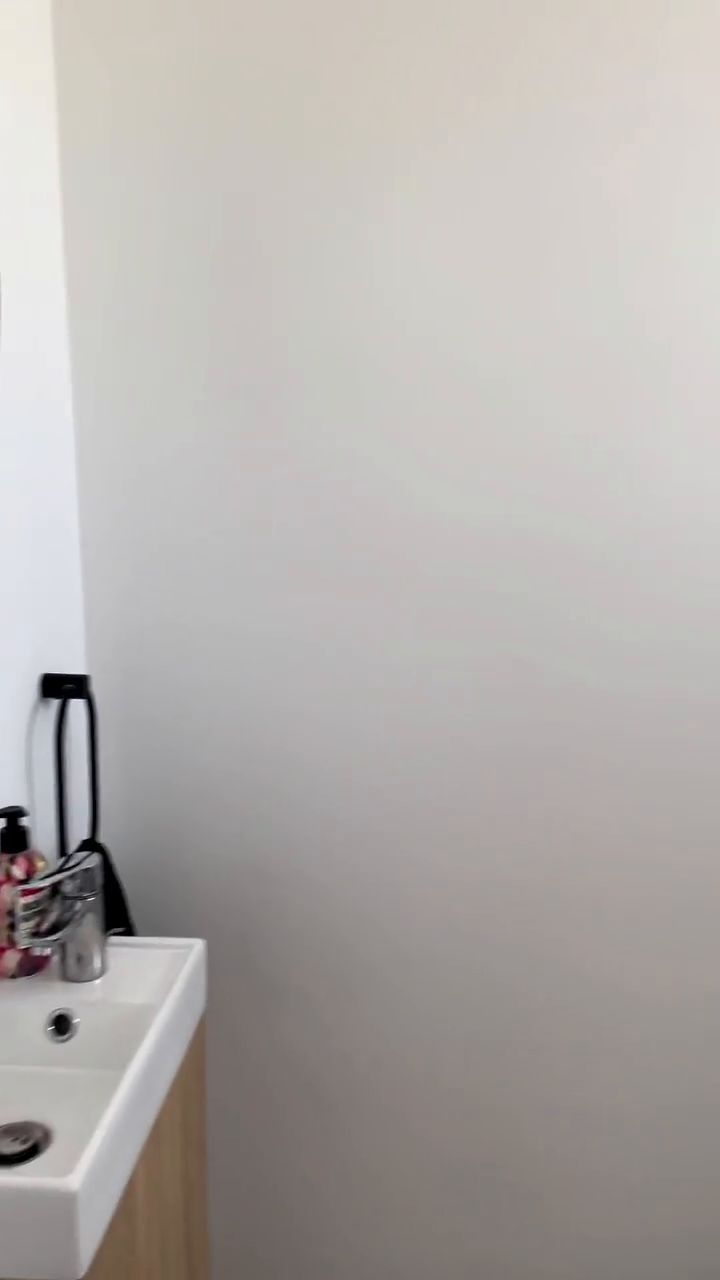 Bathroom corner with white sink, chrome faucet, and soap dispenser.