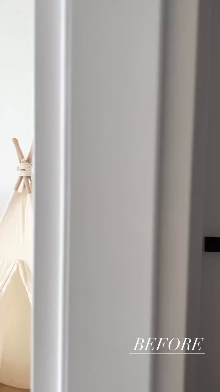 A peek at a white canvas teepee with wooden poles, seen through a doorway.