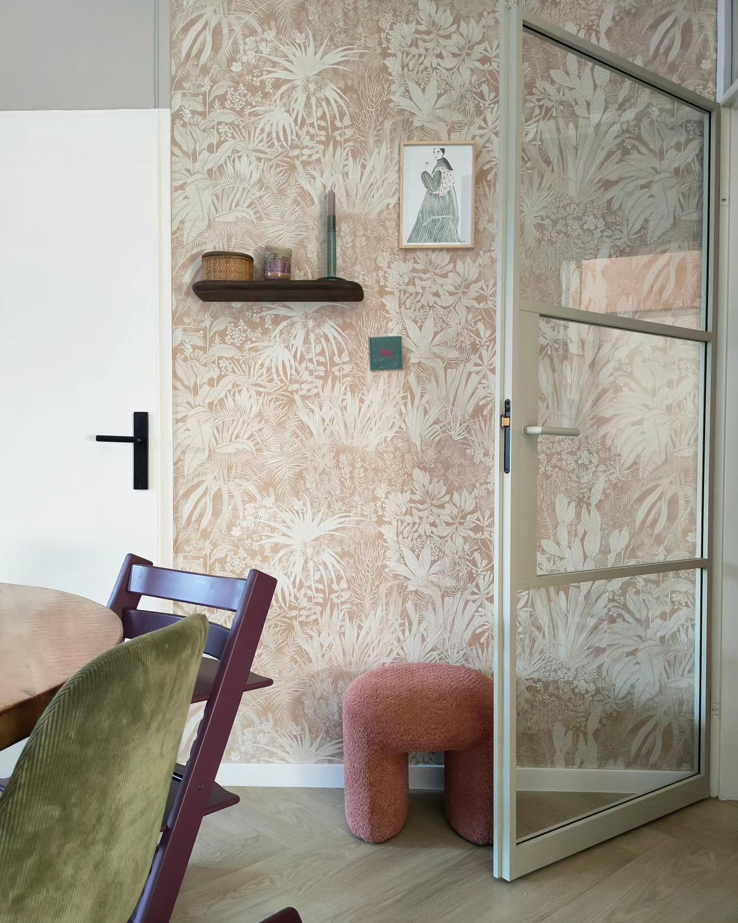 Interior with floral wallpaper, glass door, and purple high chair.