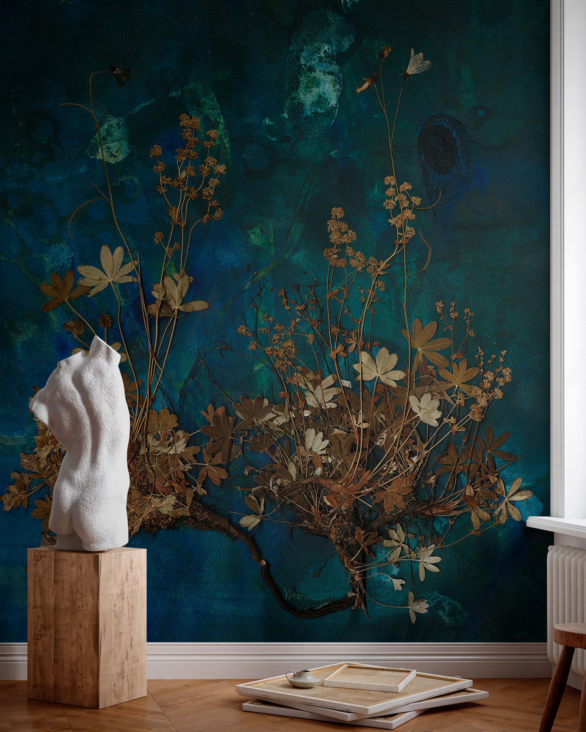 Interior with blue floral wallpaper, white torso sculpture on wood block.