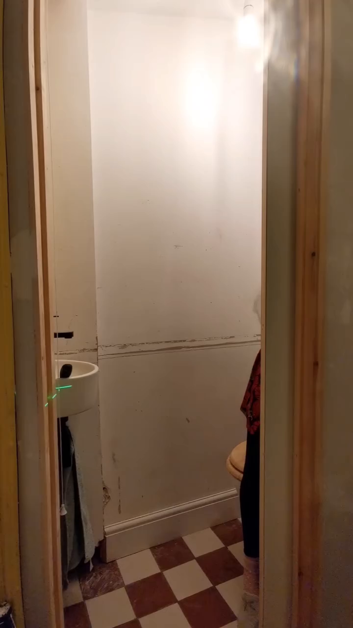 View into a small bathroom with red and white checkered floors.