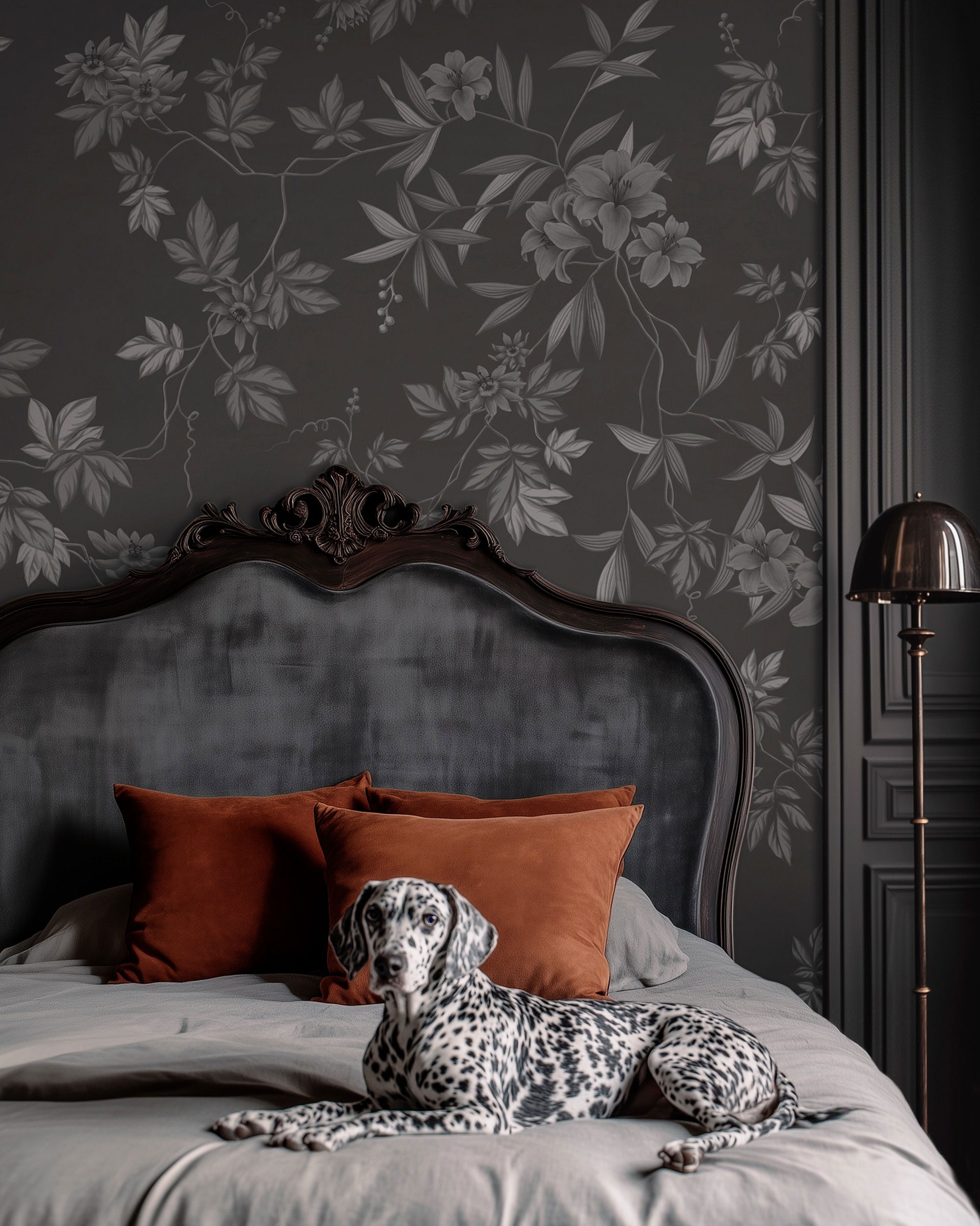 Dalmatian lounging on a bed with orange pillows, floral wallpaper.