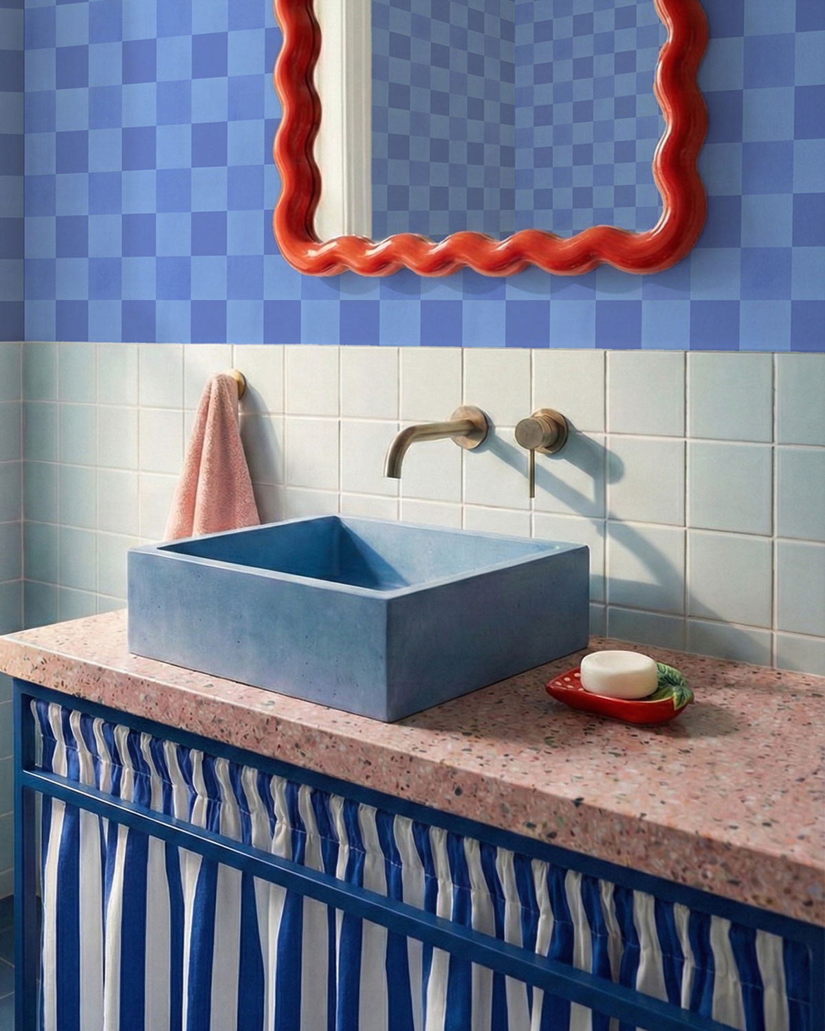 Blåvask gråsvart vask på rosa flekkete benkeplate med blått og hvitt stripete gardin og rødt speil med volanger.