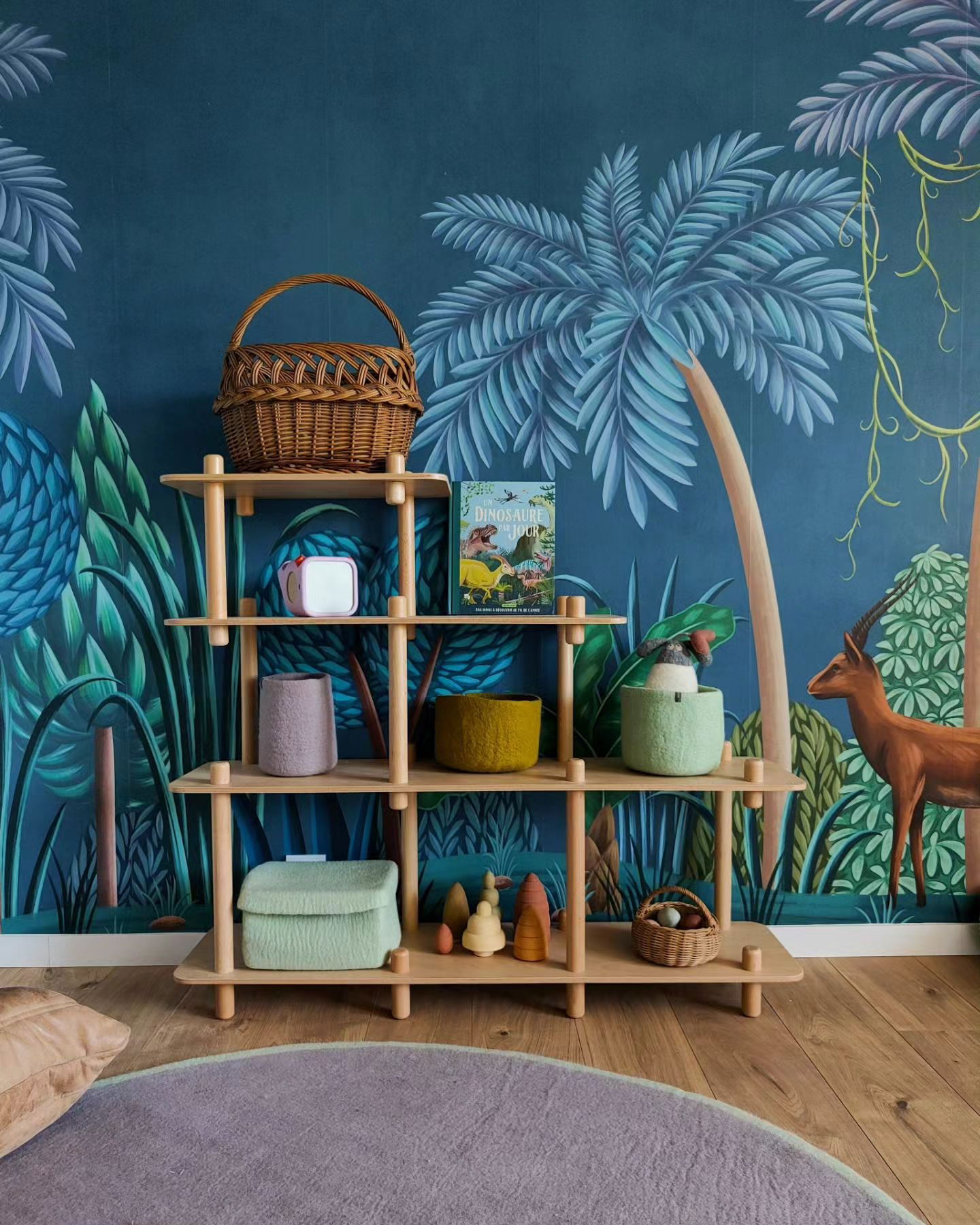Habitación infantil con papel tapiz de la jungla, estante de madera y alfombra redonda.