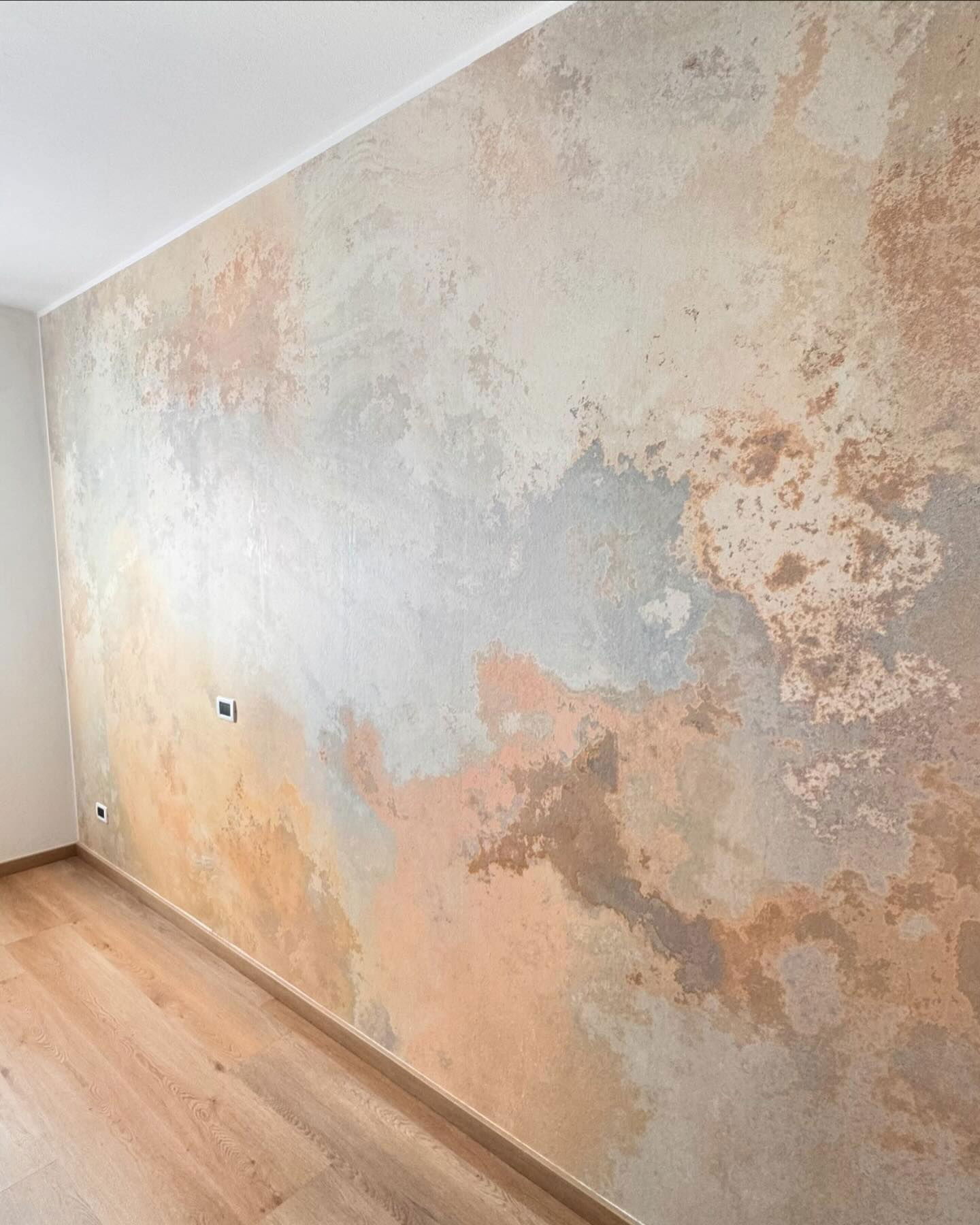 Interior wall with a mottled, abstract pattern in peach, gray, and brown tones.