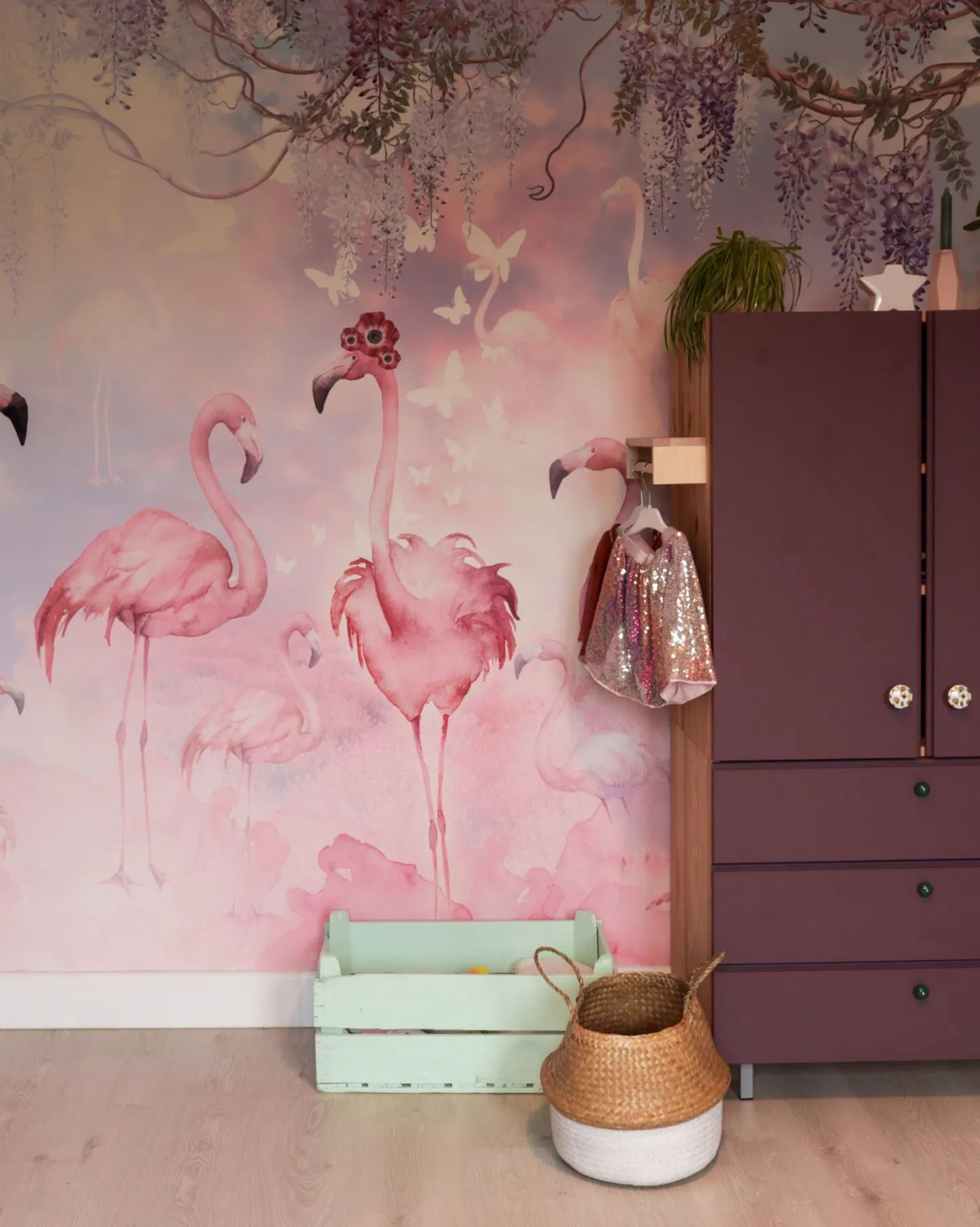Child's room with flamingo wallpaper, purple dresser, and woven basket.