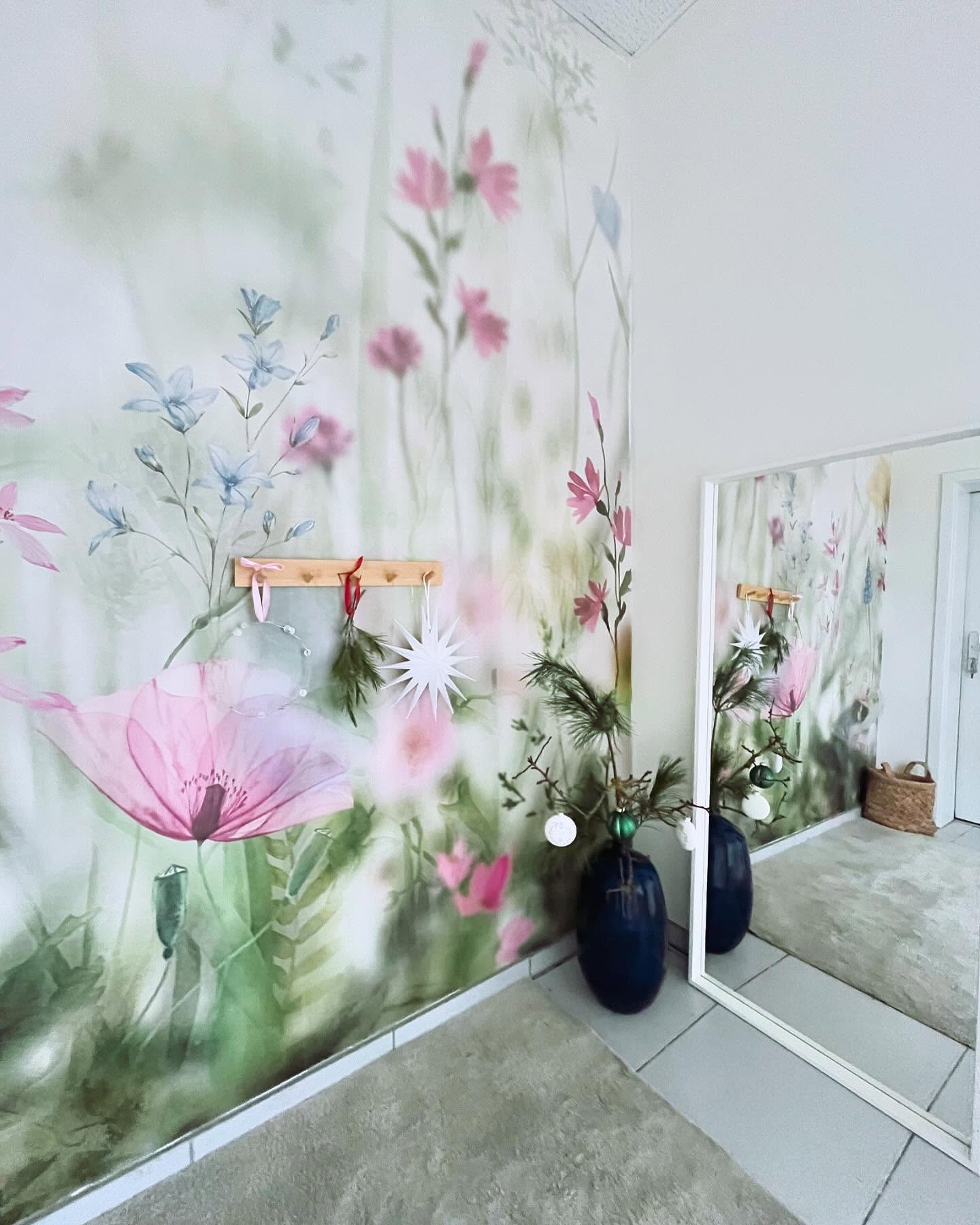 Hallway with floral wallpaper, wooden coat rack, and a mirror.