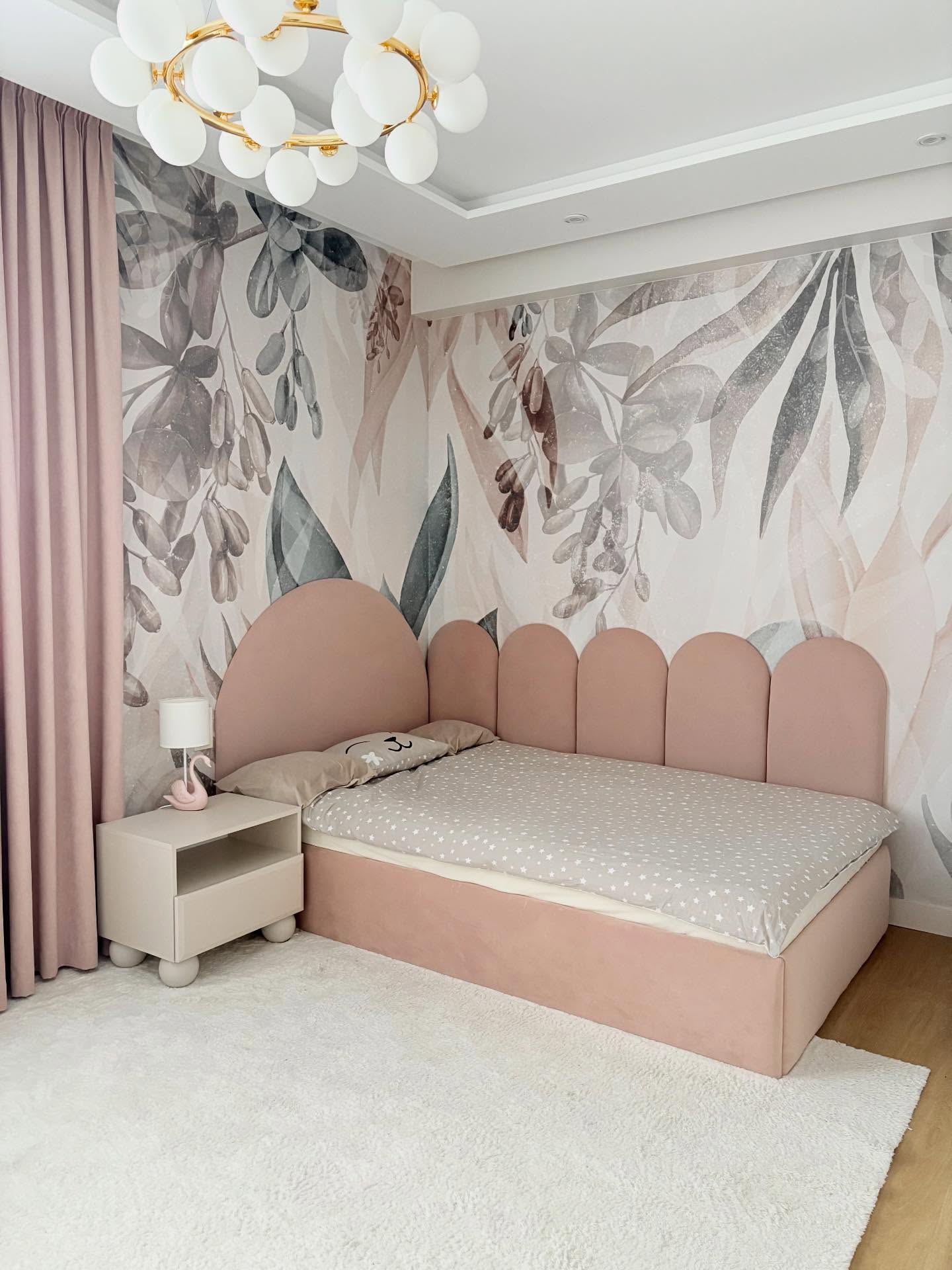 Pink upholstered bed with a leaf-patterned wallpaper and a white shag rug.