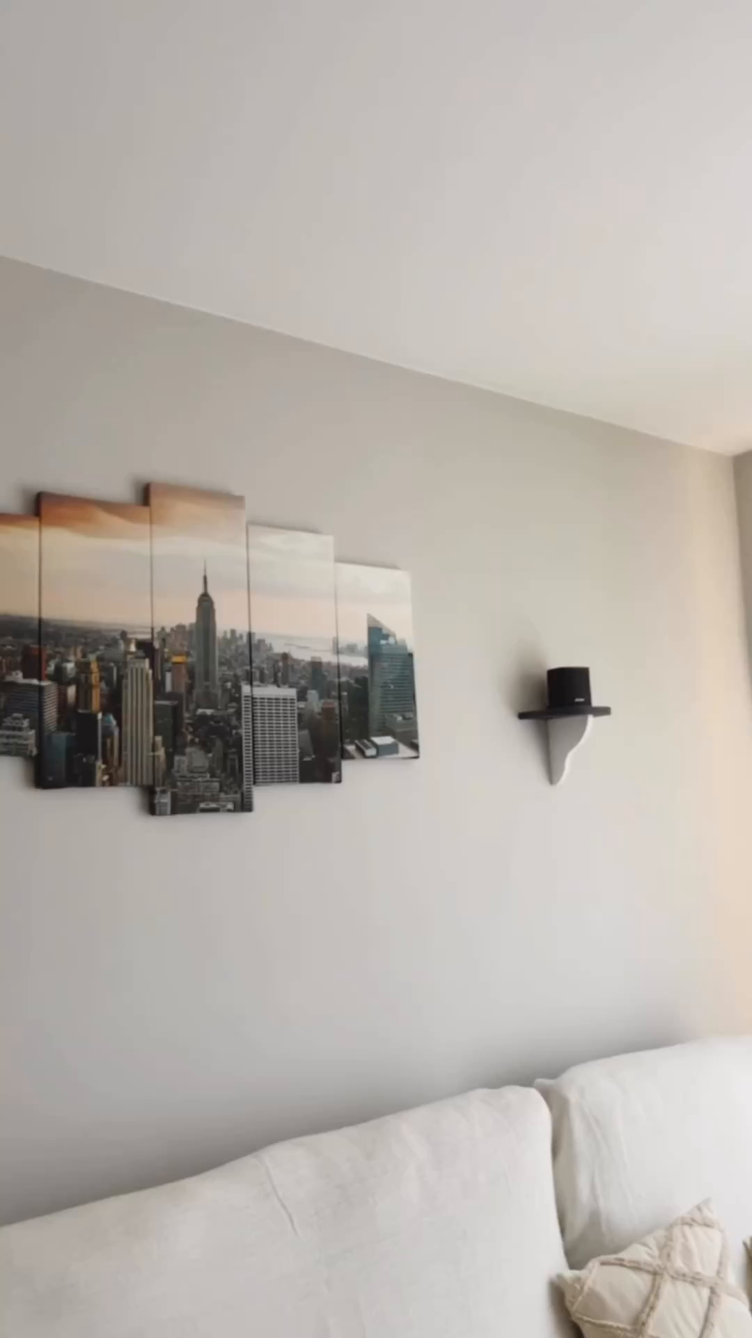 Living room with a multi-panel NYC skyline print and white sofa.