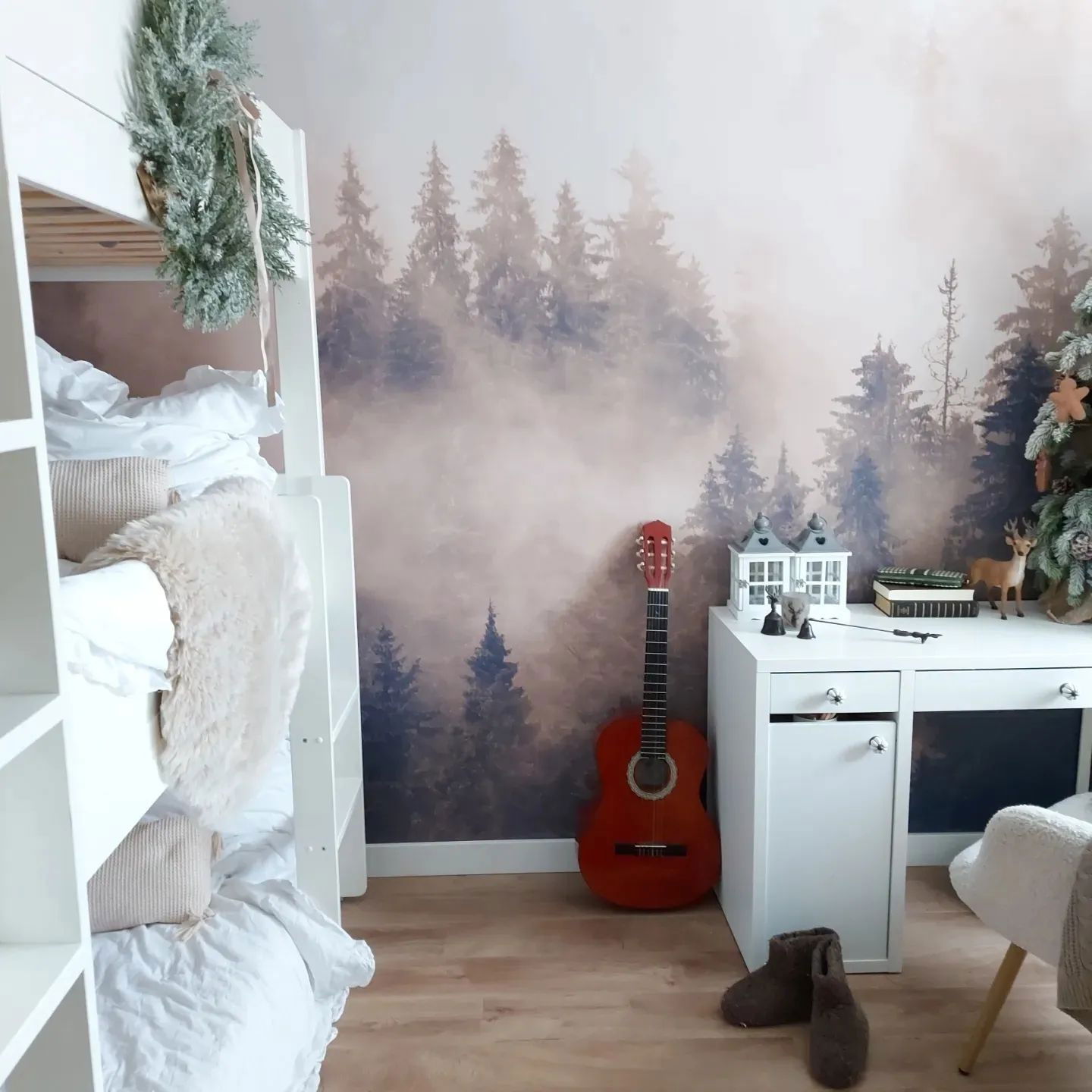Child's room with bunk bed, forest wallpaper, and white desk with red guitar.