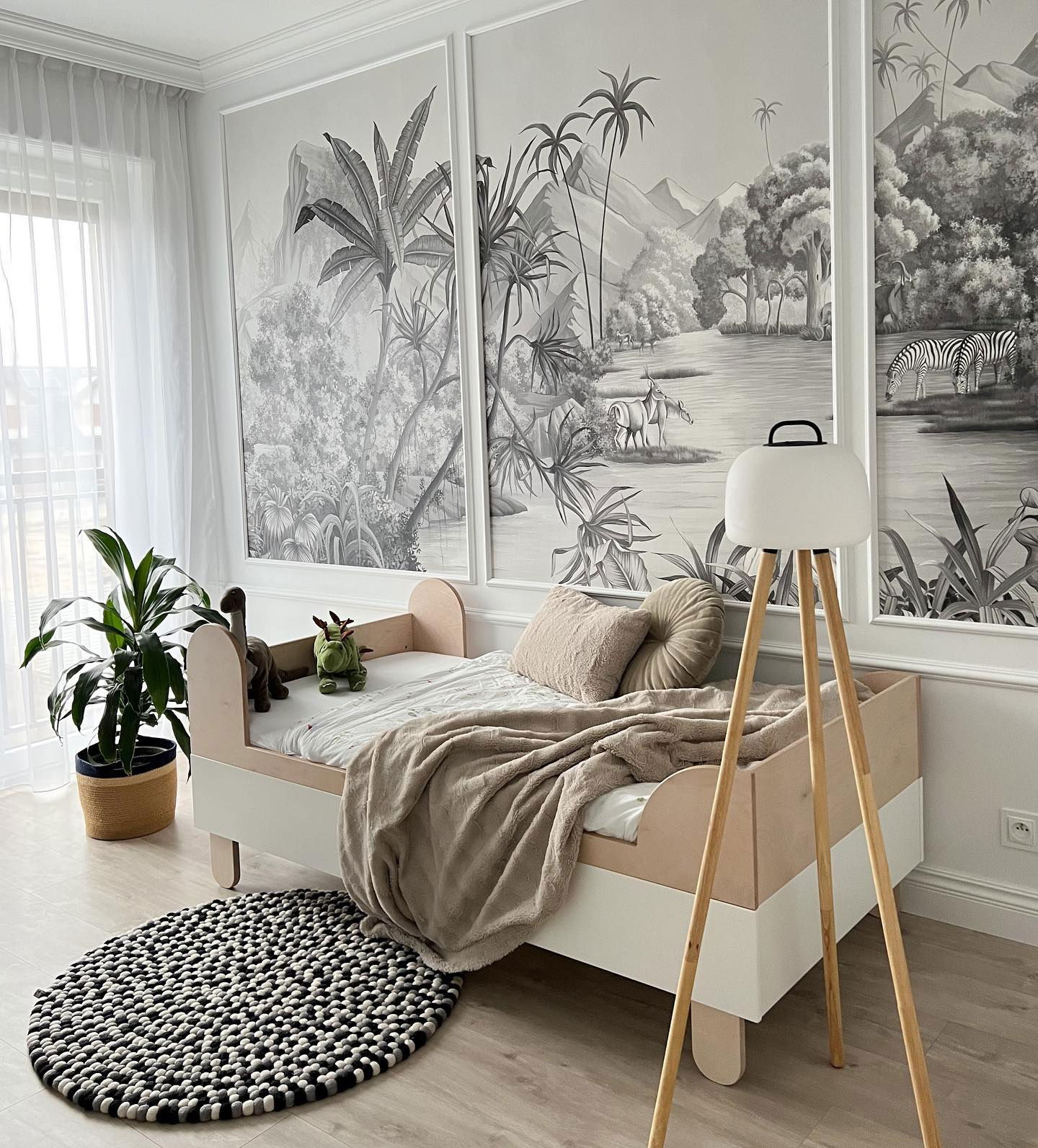 Child's bedroom with safari mural, white and wood bed, and tripod lamp.