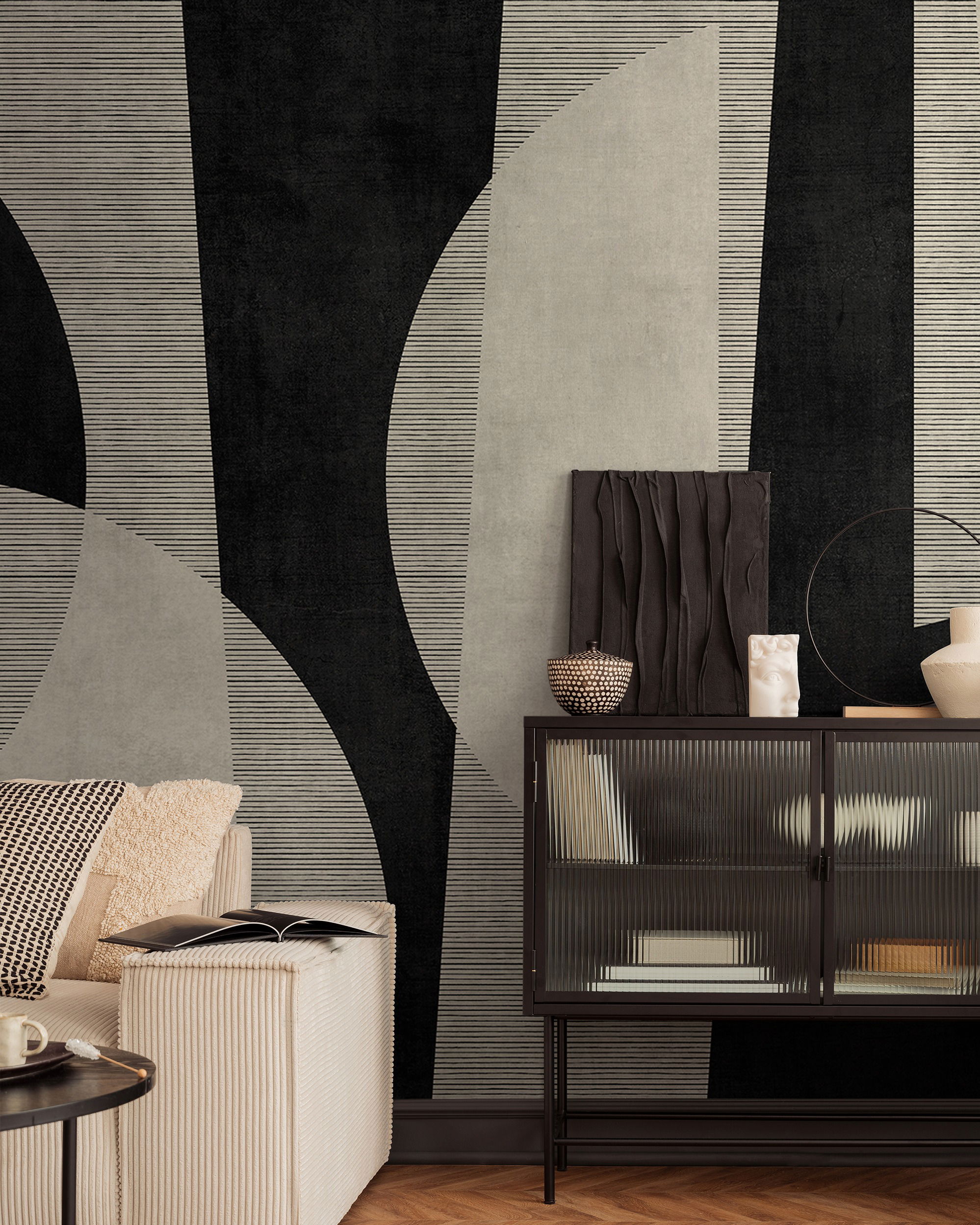 Living room with black and beige geometric wallpaper, sofa, and black cabinet.