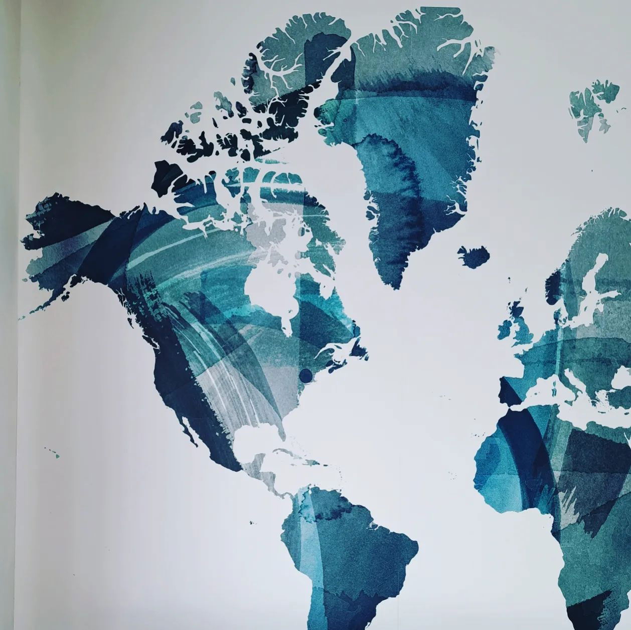 Mapa świata akwarelą w odcieniach niebieskiego i białego.