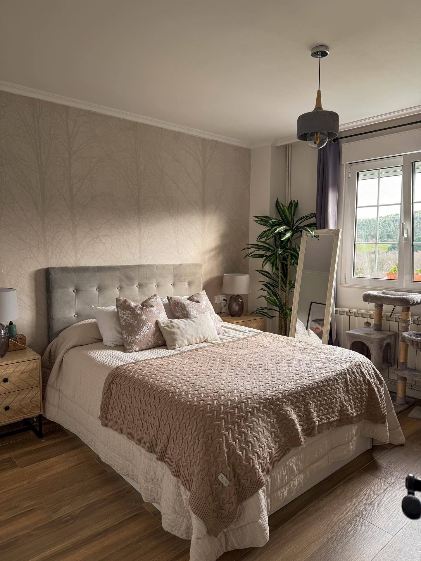 Bedroom interior with queen bed, taupe cable knit blanket, and button-tufted headboard.