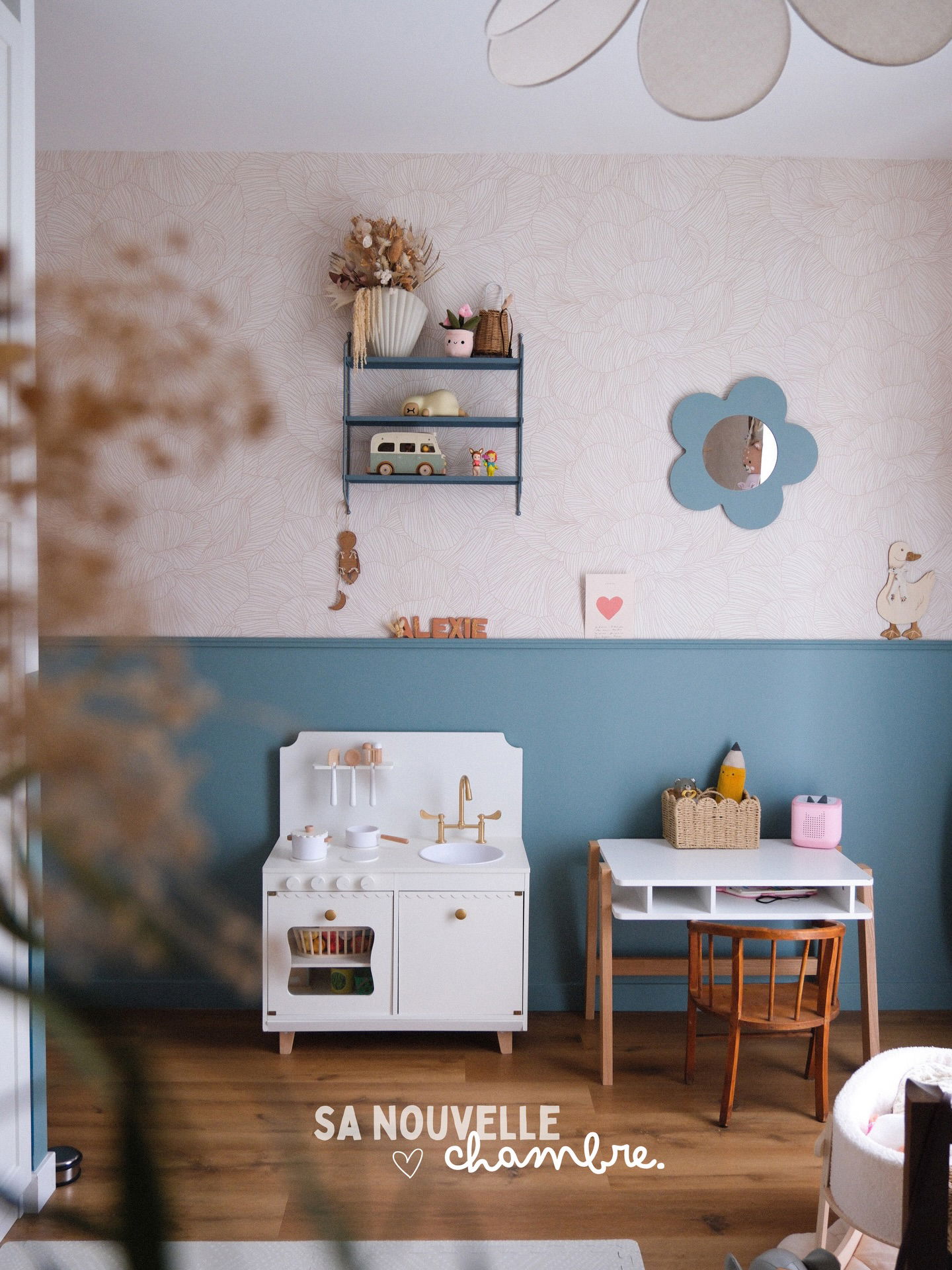 White play kitchen with gold accents and a small desk in a blue and white room.