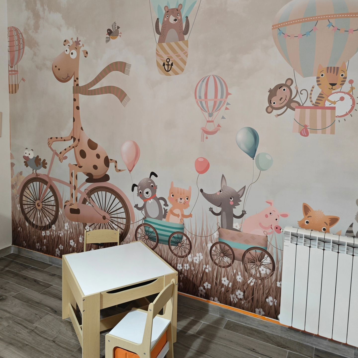 Child's room with animal-themed wallpaper and a small wooden table and chair set.