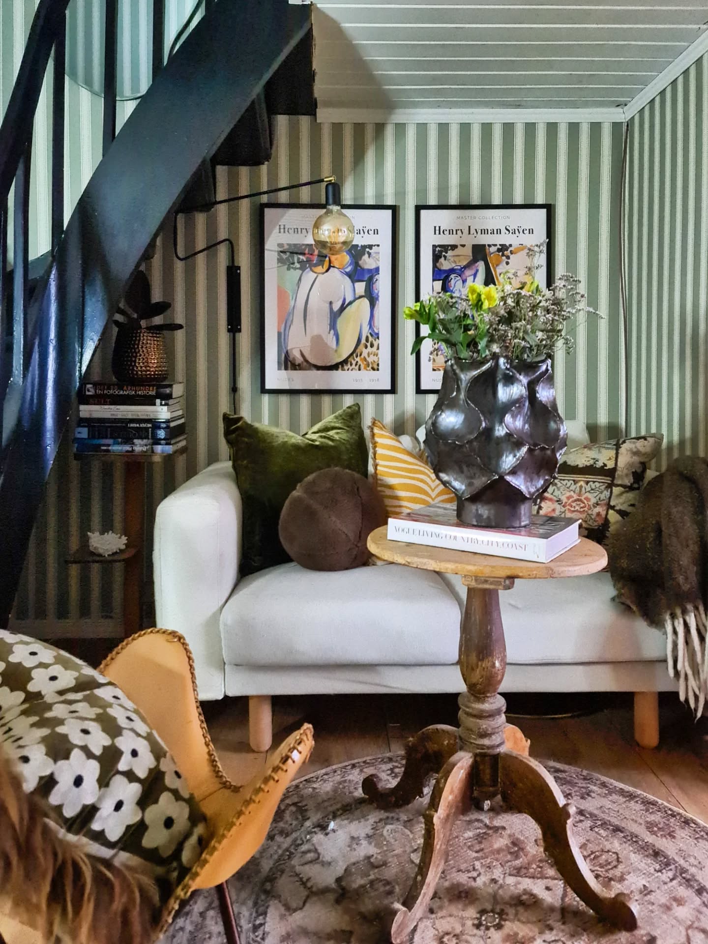 Cozy living room with striped walls, a white sofa, and vintage decor.