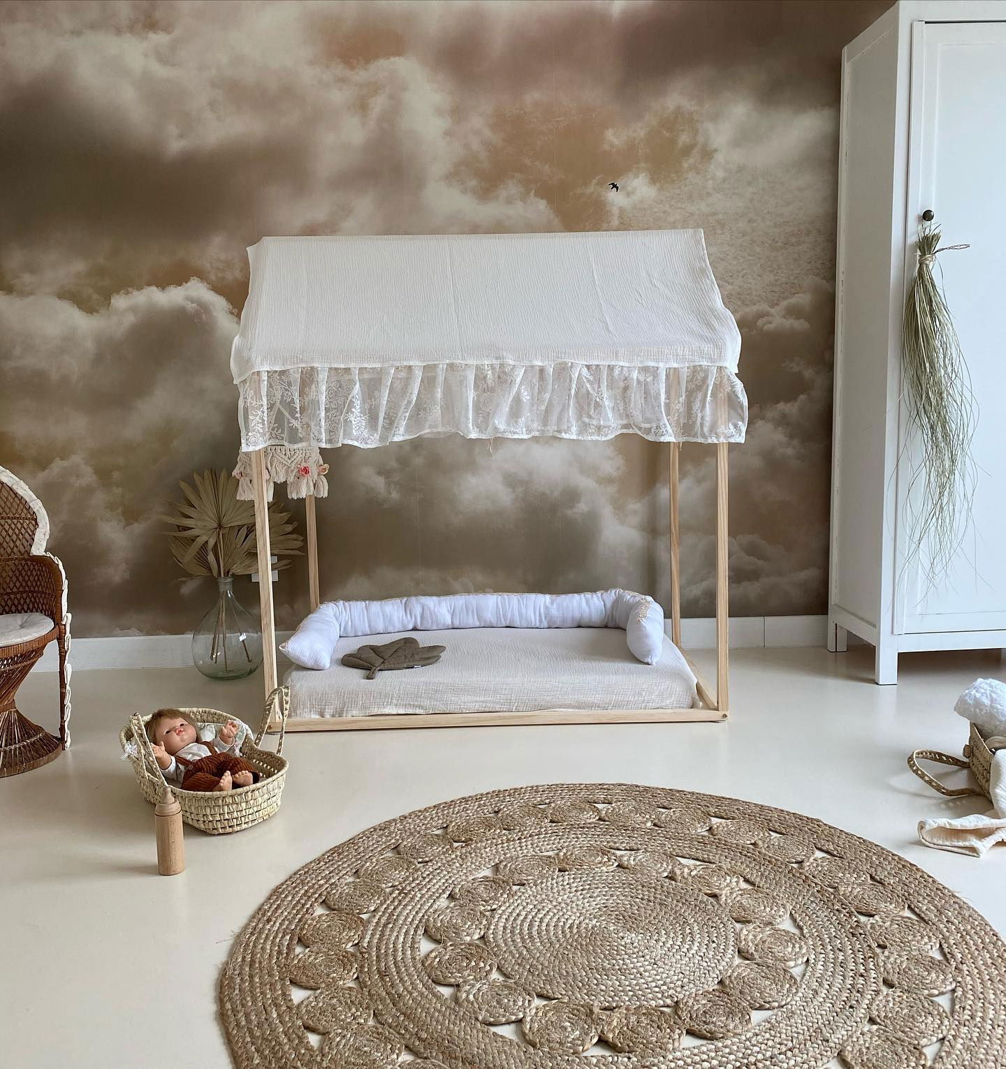 Nursery scene with canopy bed, woven rug, and doll in basket.
