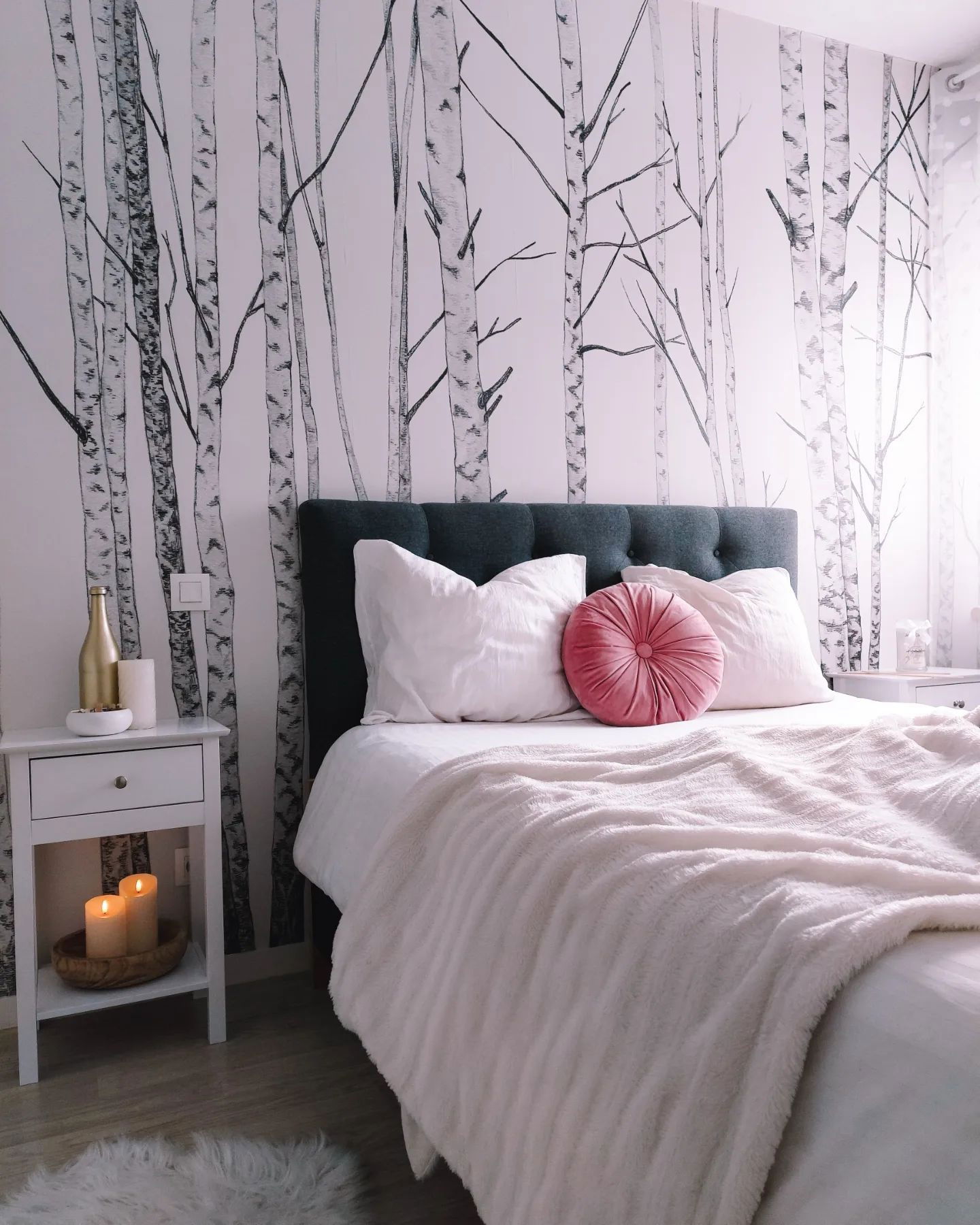 Bedroom with birch tree wallpaper, gray headboard, white bedding, and pink velvet pillow.