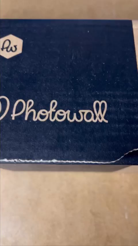 Close-up of a blue Photowall box with the brand's logo.