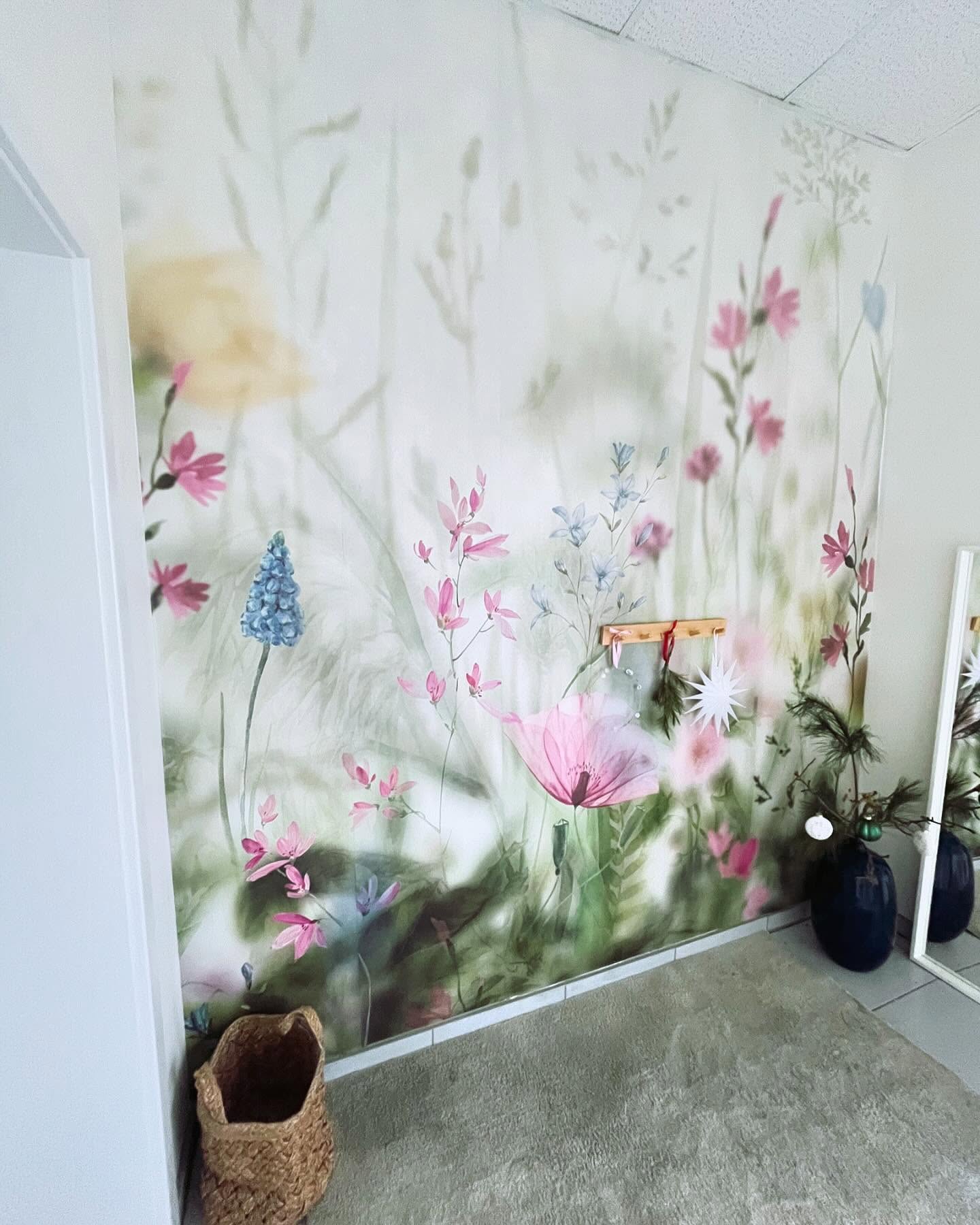 Hallway with floral wallpaper, woven basket, and blue vases.