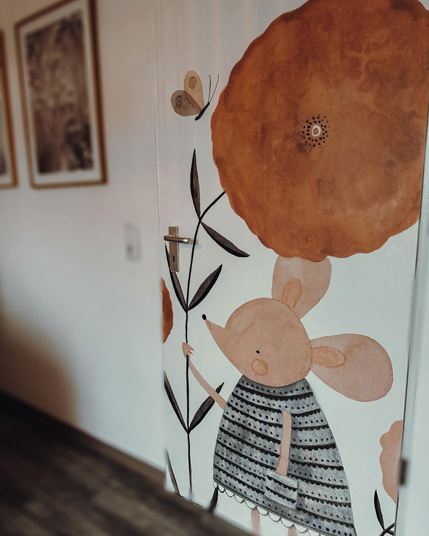 Door with a whimsical illustration of a mouse, flower, and butterfly.