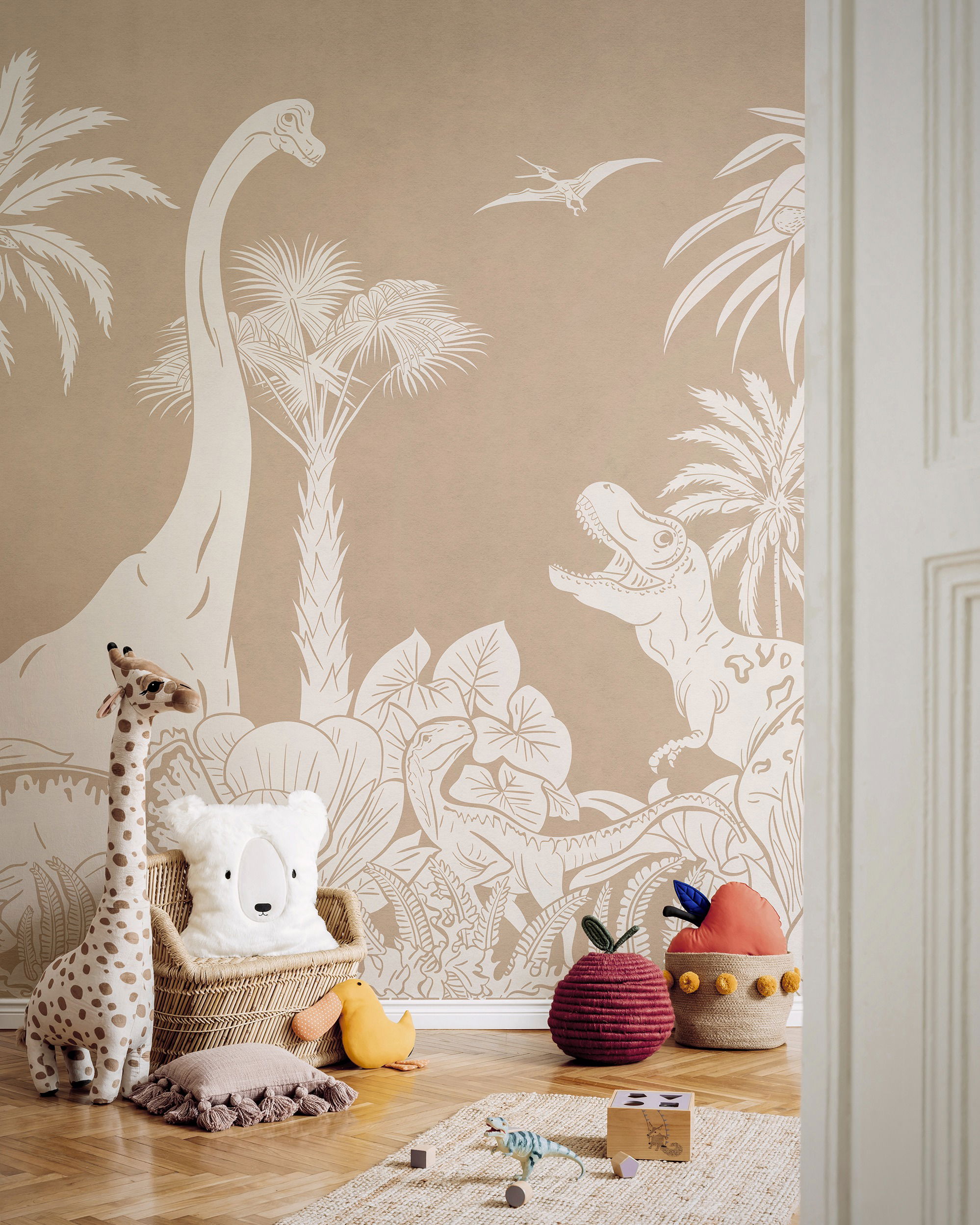 Chambre d'enfant avec papier peint dinosaure, peluche girafe et rangement en pomme tressée.