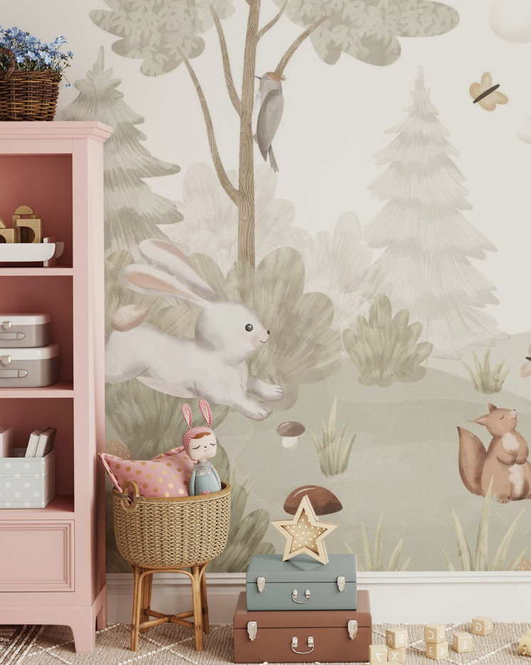 Nursery with pink bookshelf, forest-themed wallpaper, and wicker basket with toys.