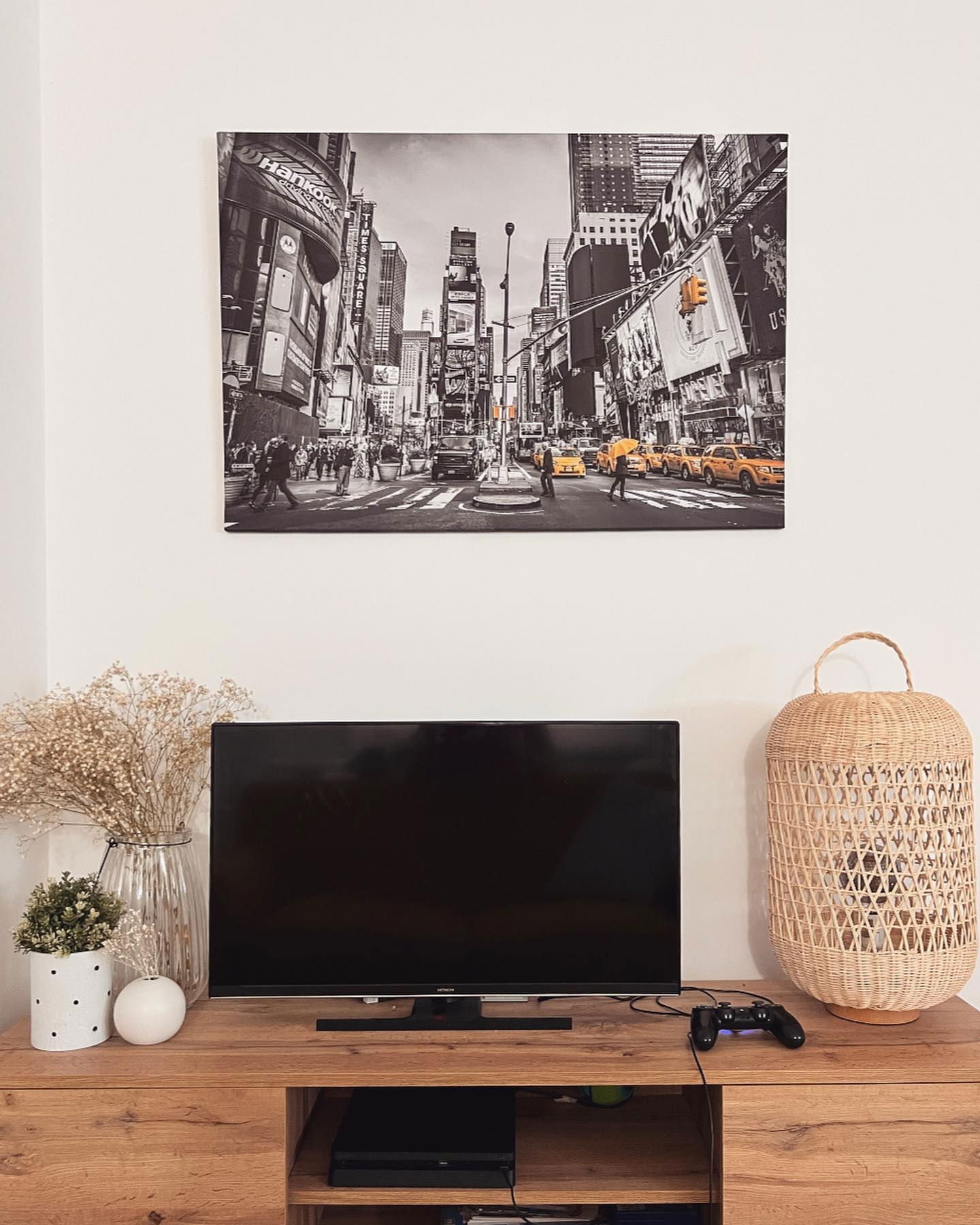 Aranżacja salonu z telewizorem, dekoracjami i czarno-białym zdjęciem Times Square.