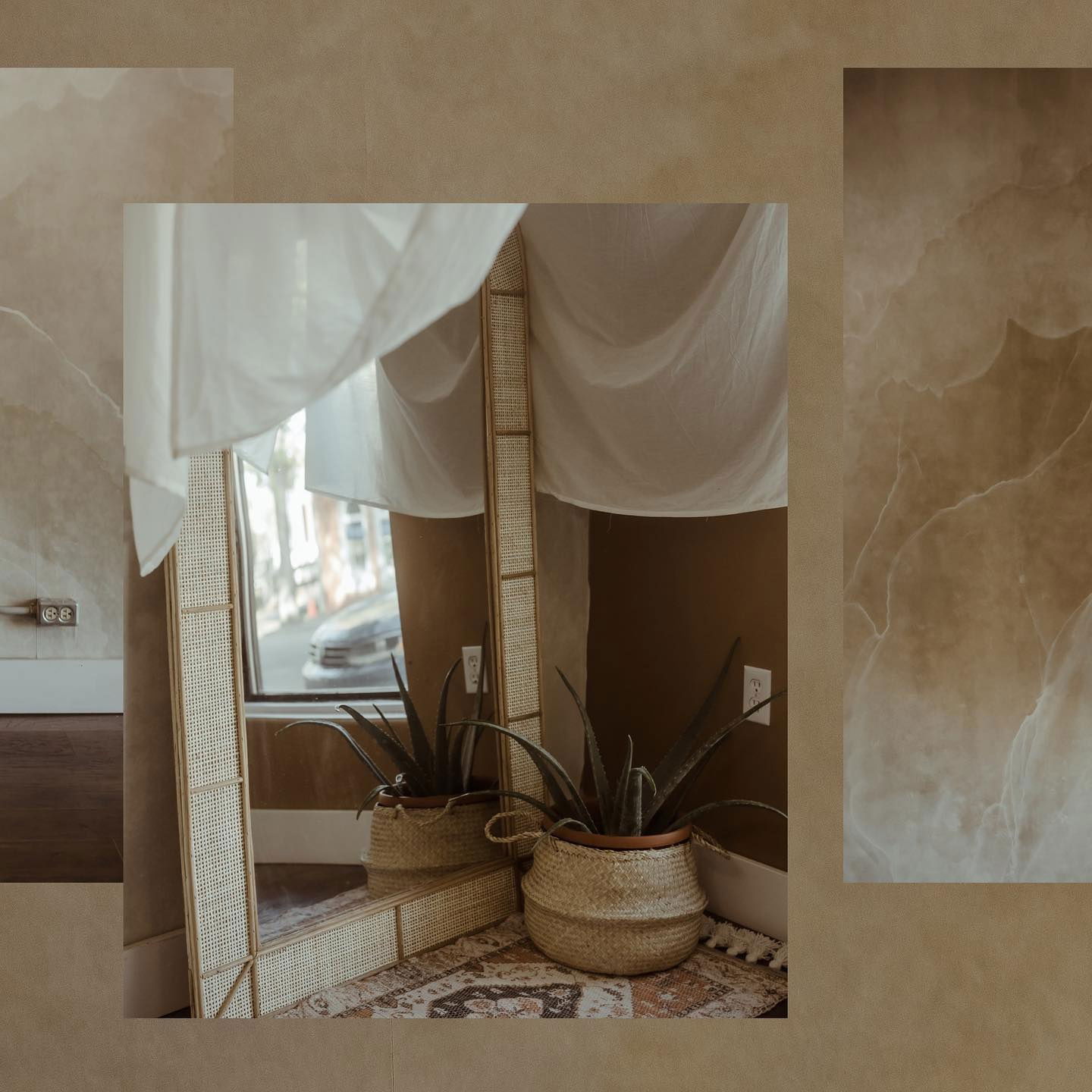 Interior con un espejo de caña, cortinas blancas y plantas en macetas sobre una alfombra estampada.