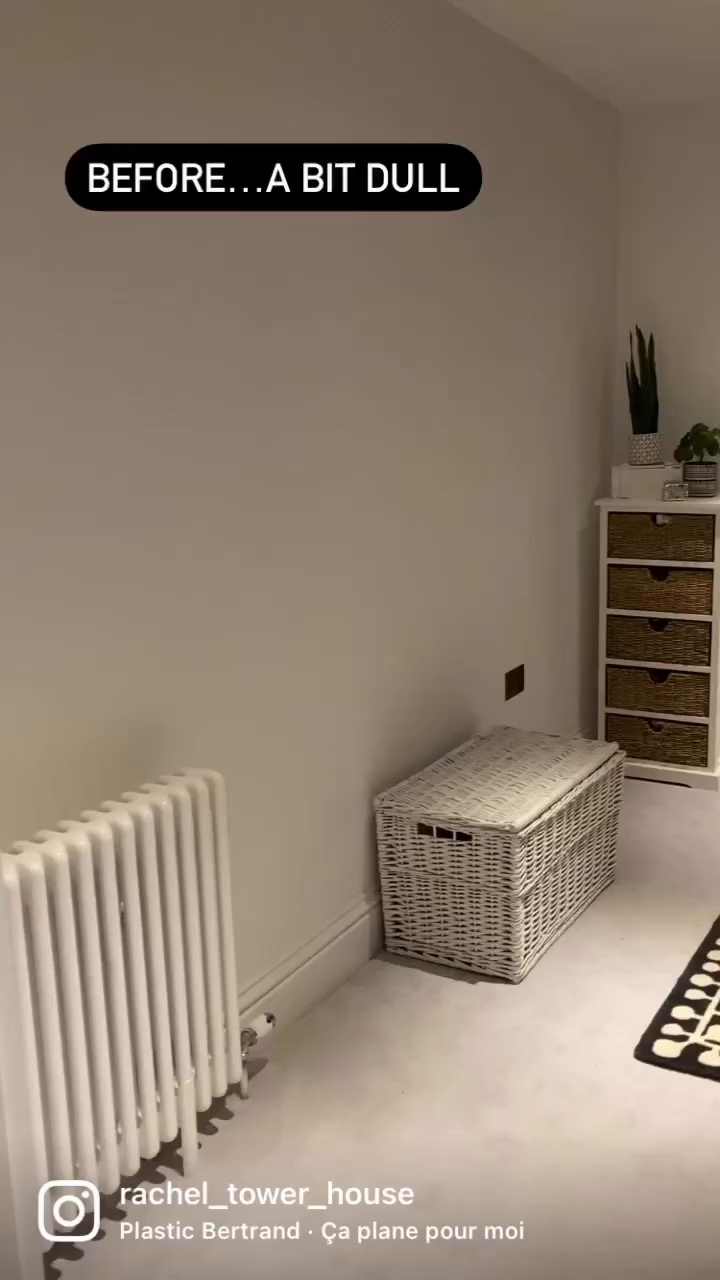 A room with white walls, a radiator, a wicker chest, and a cabinet with wicker drawers. Text overlay: "BEFORE...A BIT DULL".