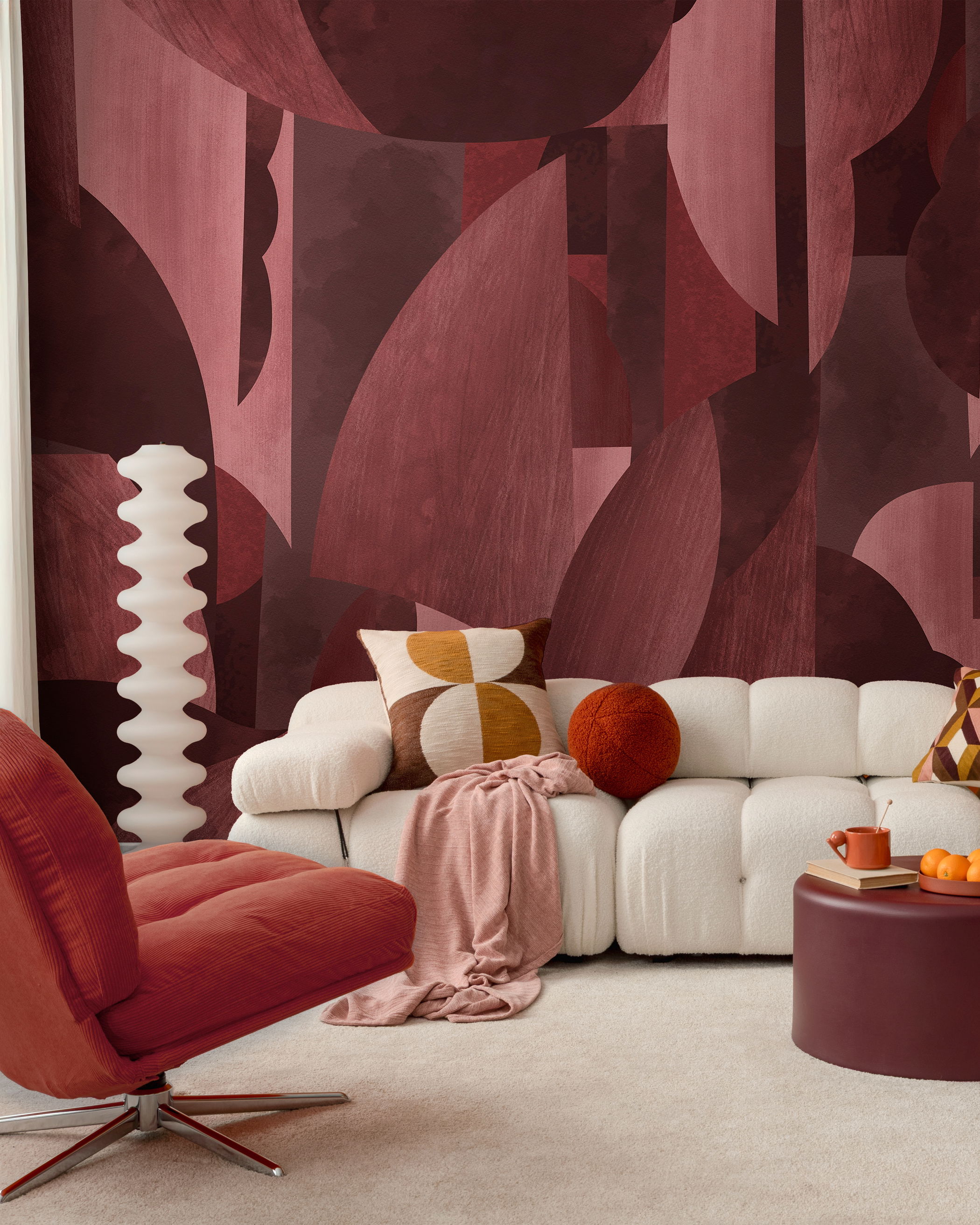 Living room with maroon geometric wallpaper, cream sofa, and orange chair.