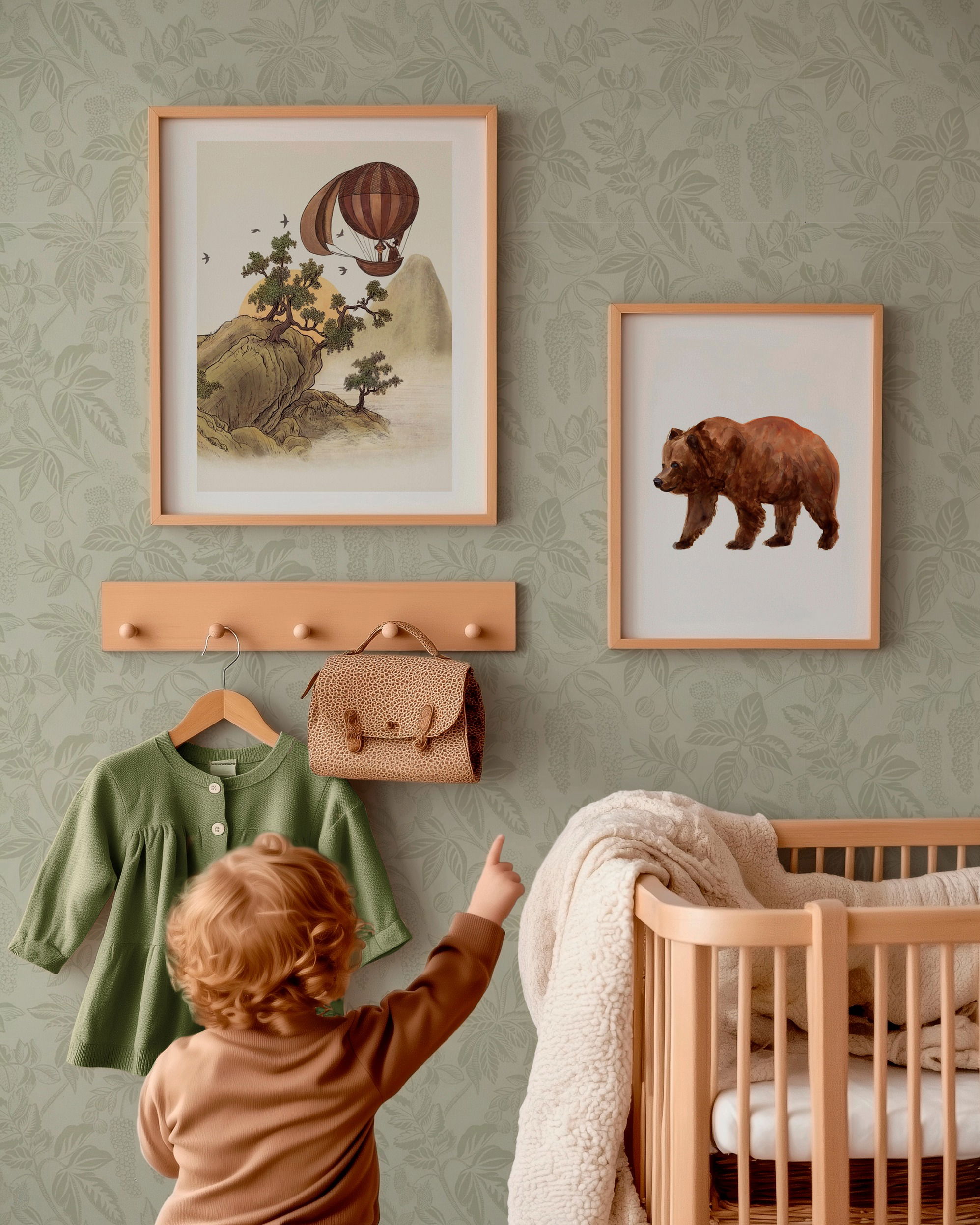 Child pointing at framed bear art in nursery with crib, clothes rack, green shirt, and satchel.