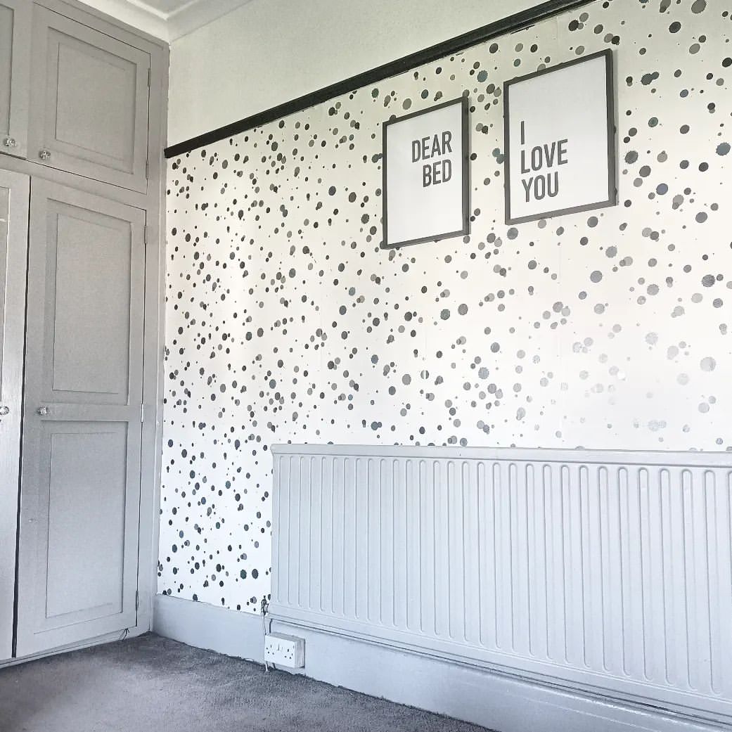 Bedroom corner with gray wardrobe, radiator, and framed prints. "Dear Bed" and "I Love You" art on polka dot wallpaper.