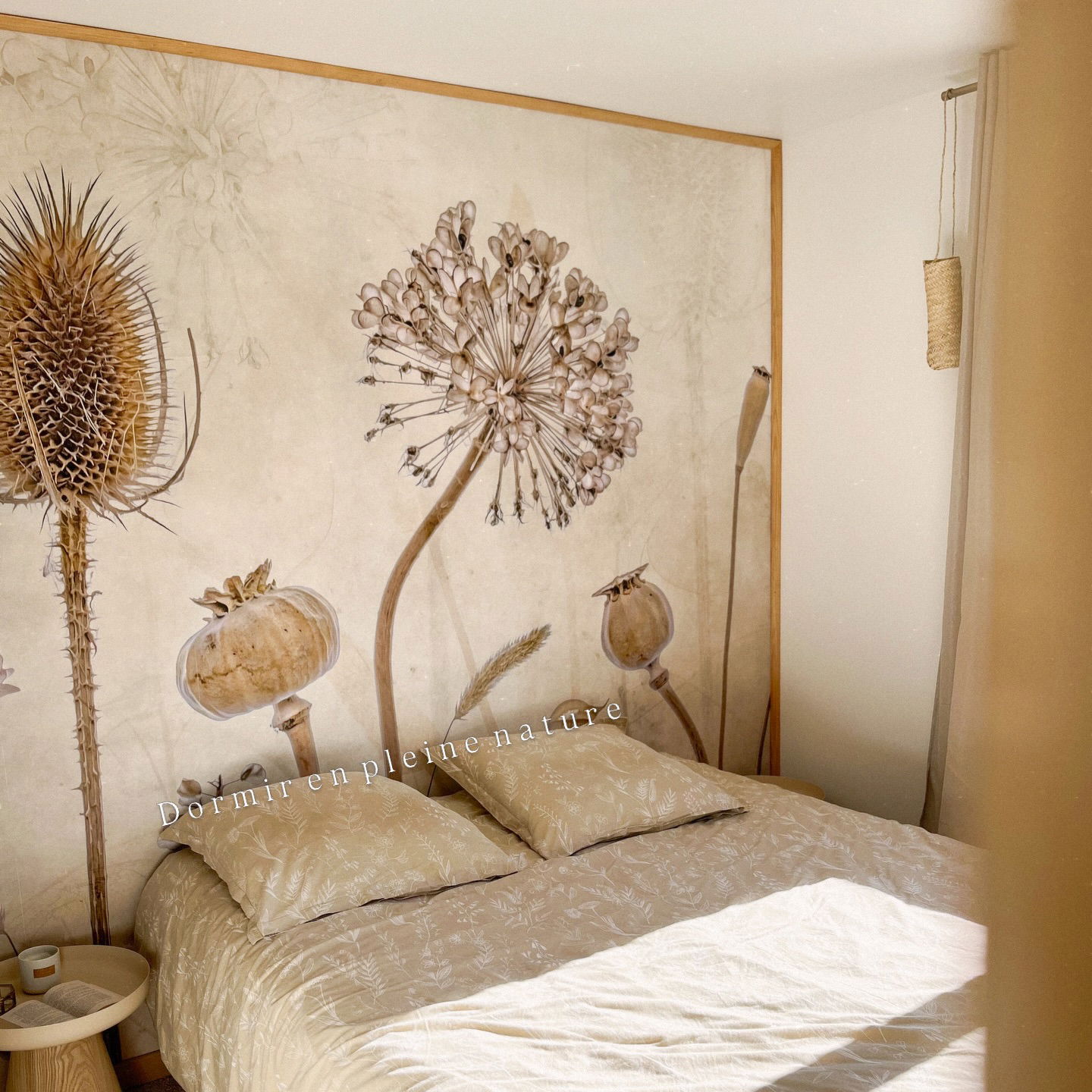 Bedroom with dried flower mural and neutral bedding.