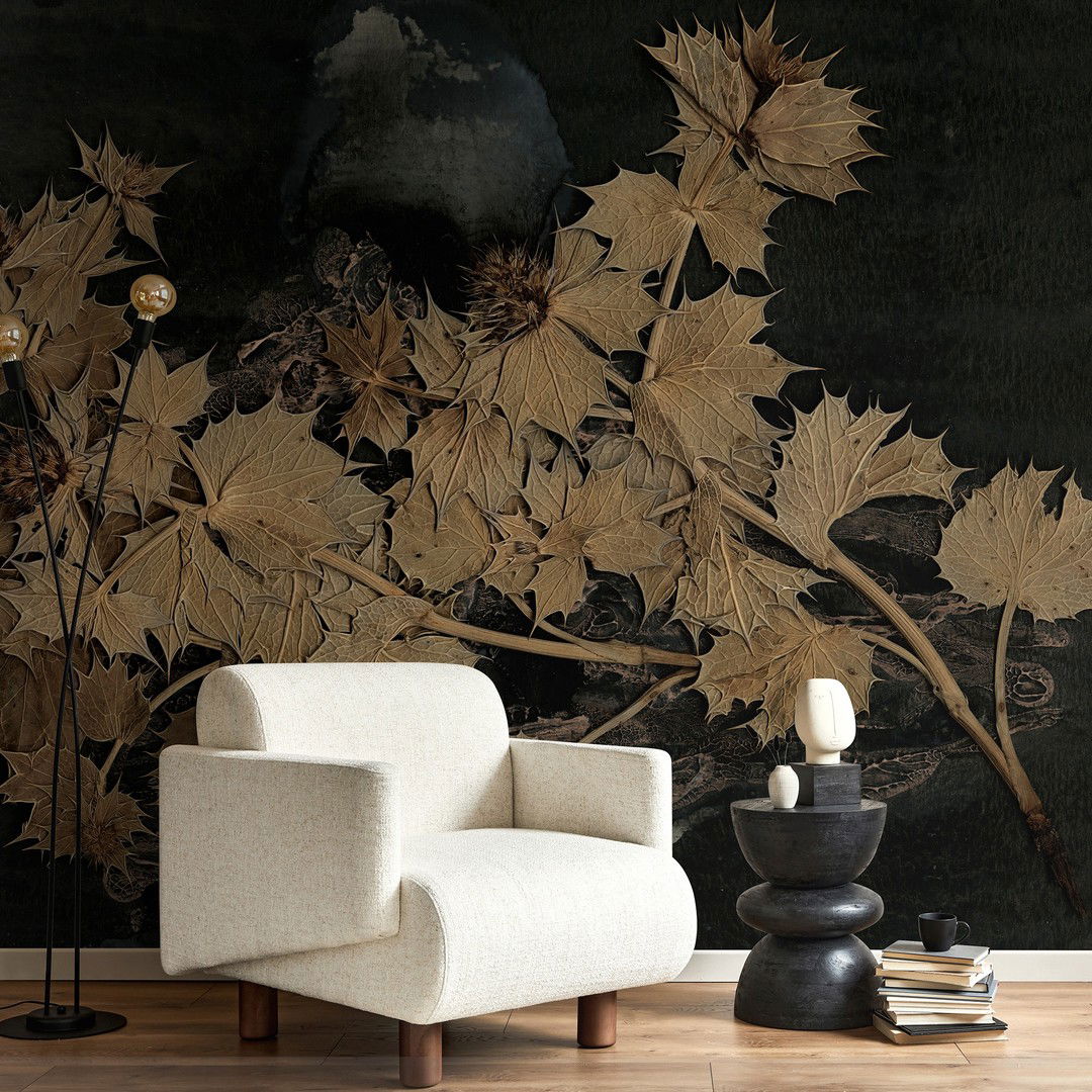 Living room scene with white armchair, black side table, books, and botanical wallpaper.