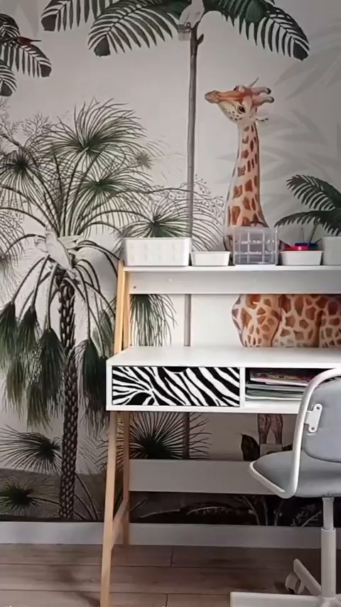 Child's desk with zebra print drawer, against a jungle-themed wallpaper with giraffe.
