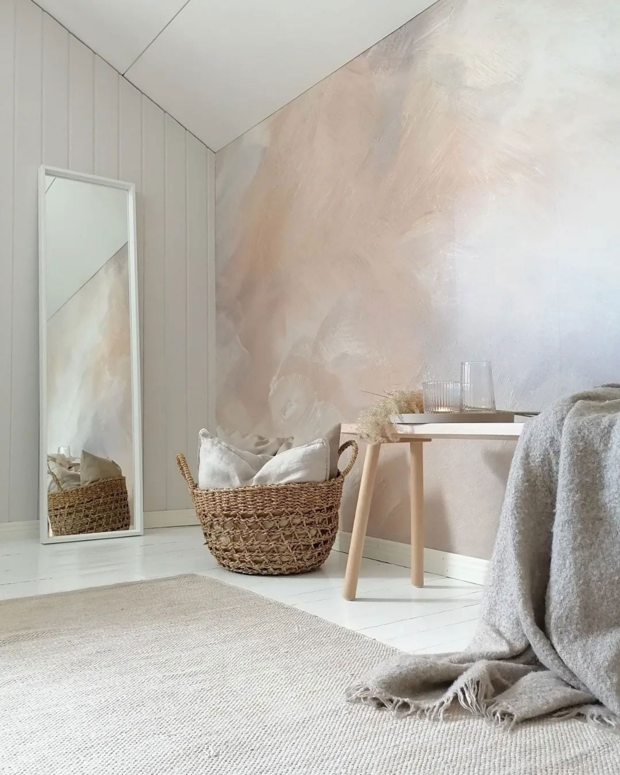 Cozy bedroom corner with woven basket, stool, and full-length mirror.